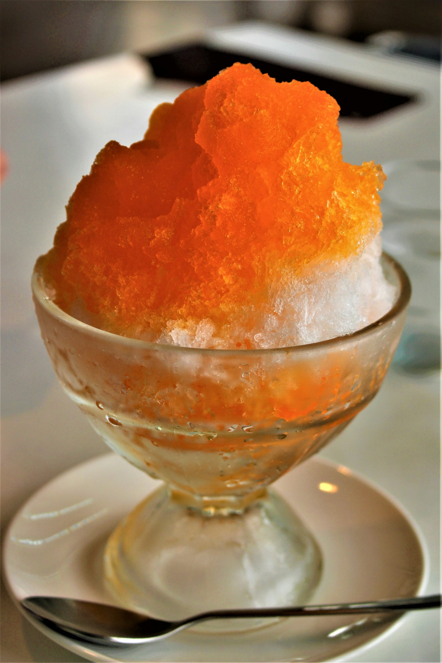 Orange shaved ice served in a crystal bowl