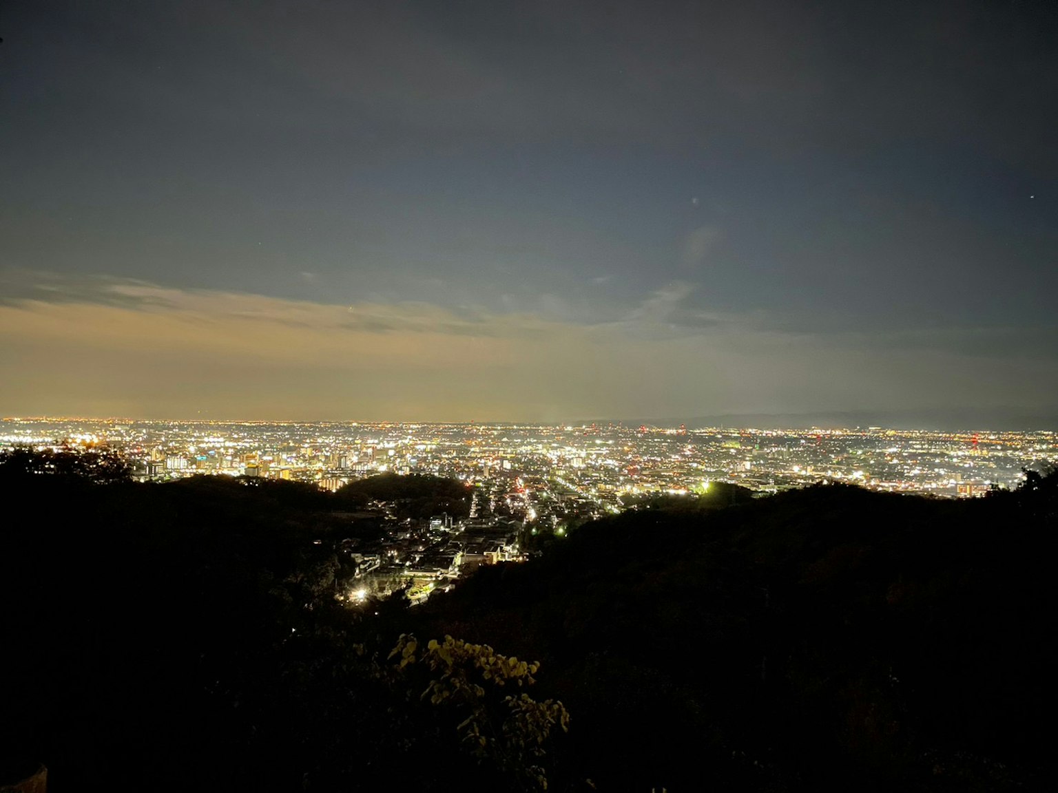 夜晚城市的全景，明亮的灯光和黑暗的山脊轮廓