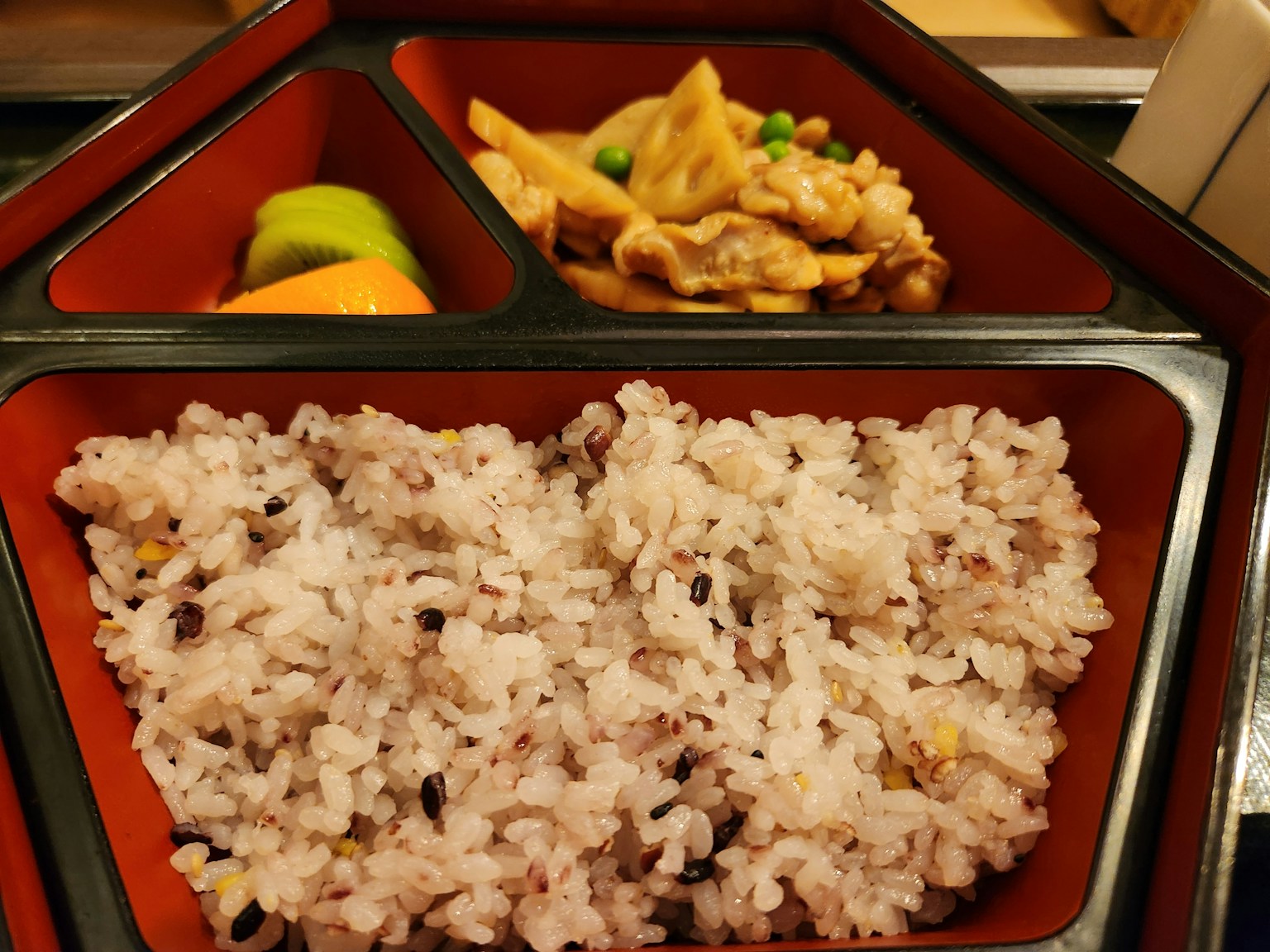 お弁当の中に黒米と鶏肉の料理が見える