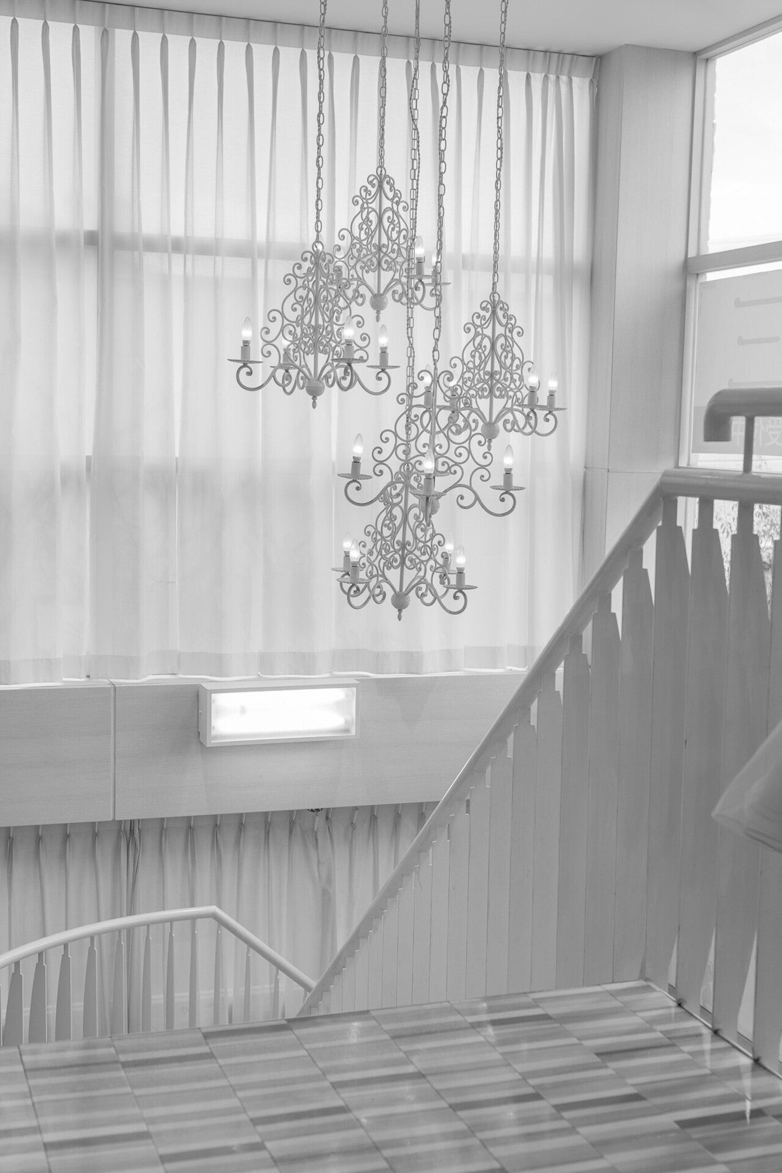 Espacio elegante con escalera y candelabros en blanco y negro
