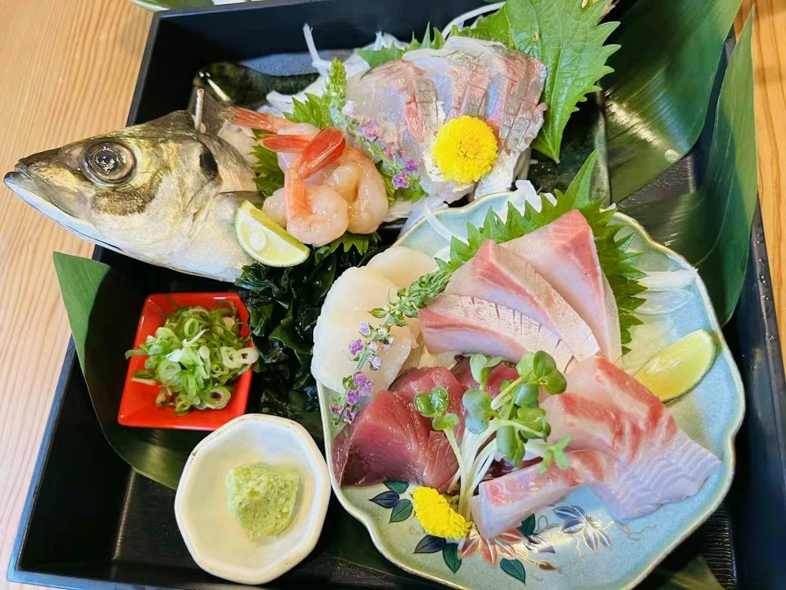 신선한 사시미와 생선 접시 생동감 있는 해산물과 허브, 라임으로 장식