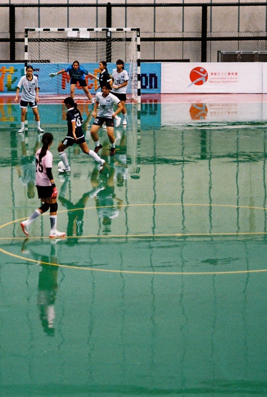Spieler jagen einen Ball auf einem Hallen-Futsalplatz