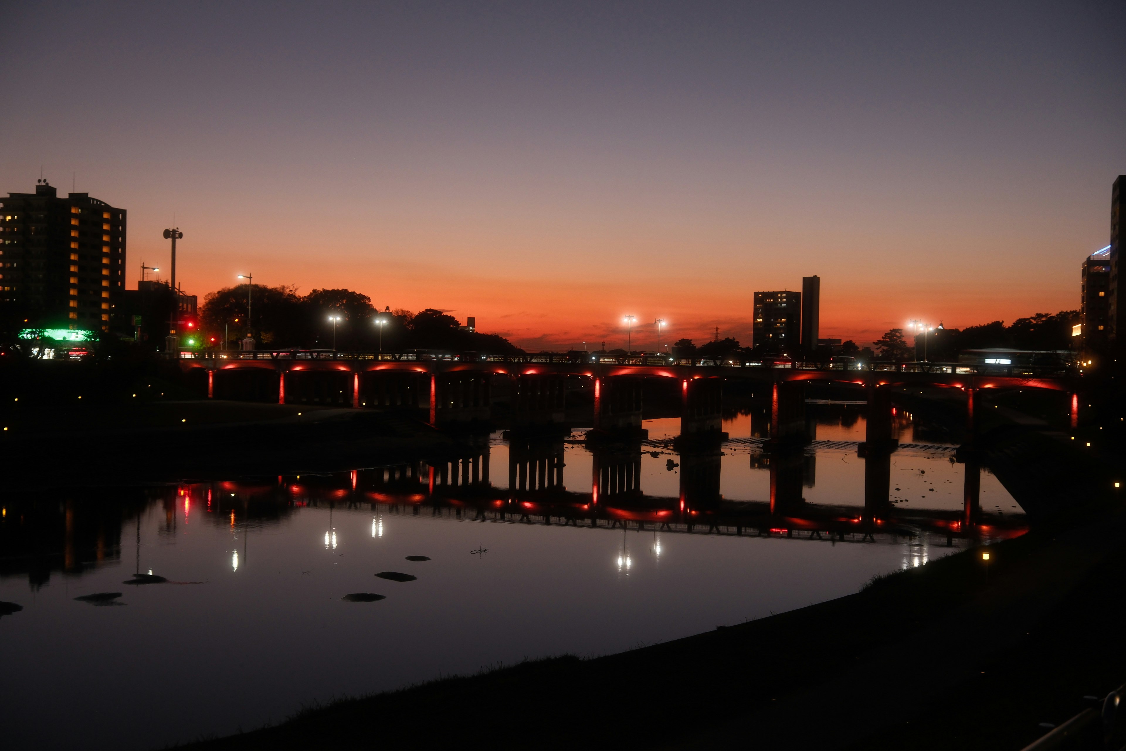 夕景の川沿いに並ぶ橋と街の夜景