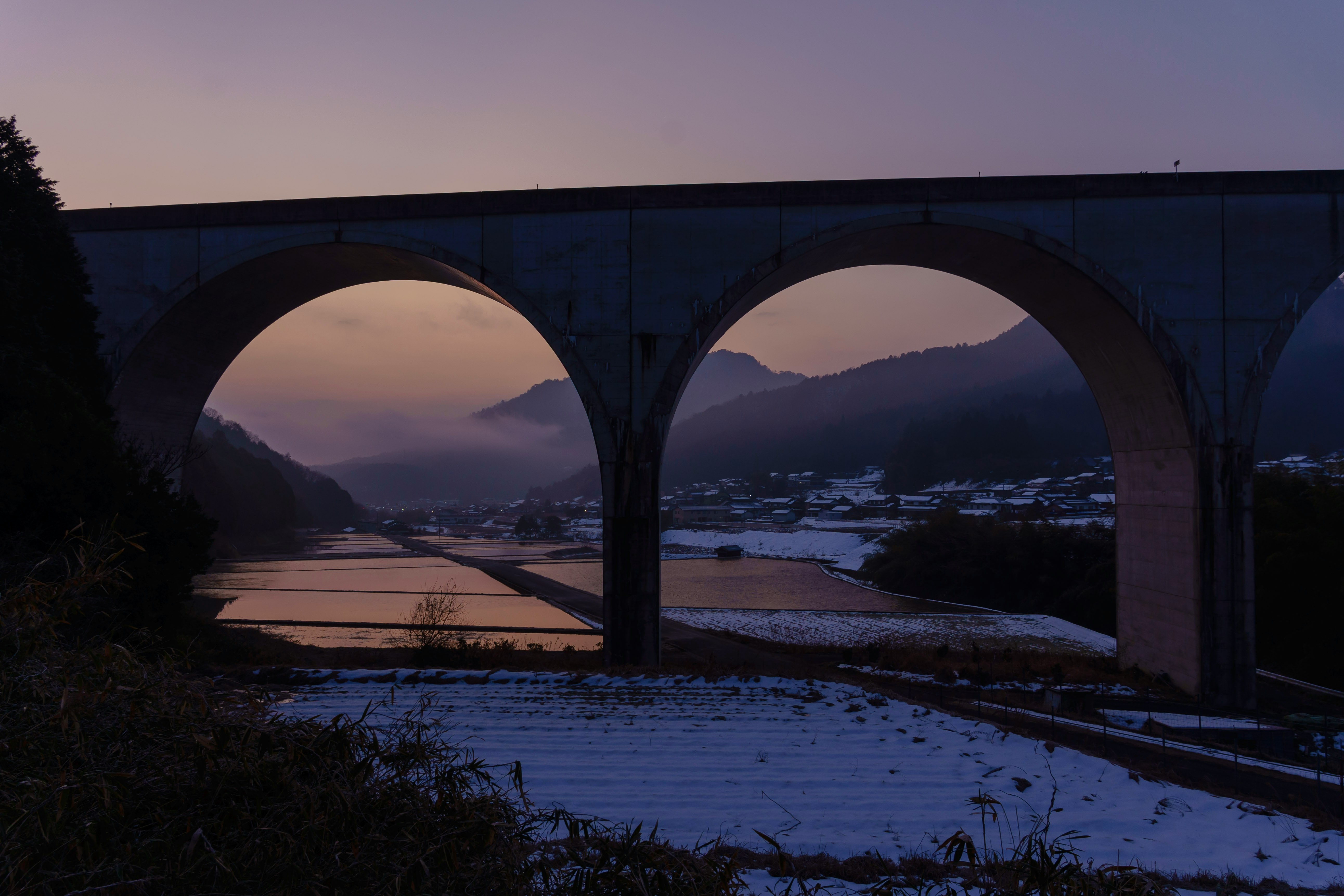 朝焼けの川とアーチ橋のある風景