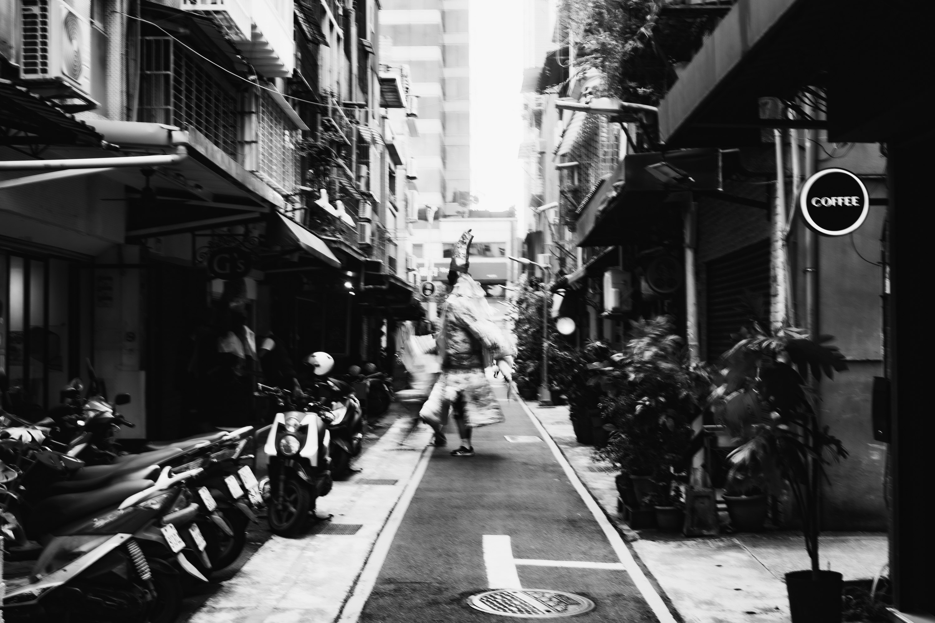 路地の店先に並ぶバイクと自転車のある商店街