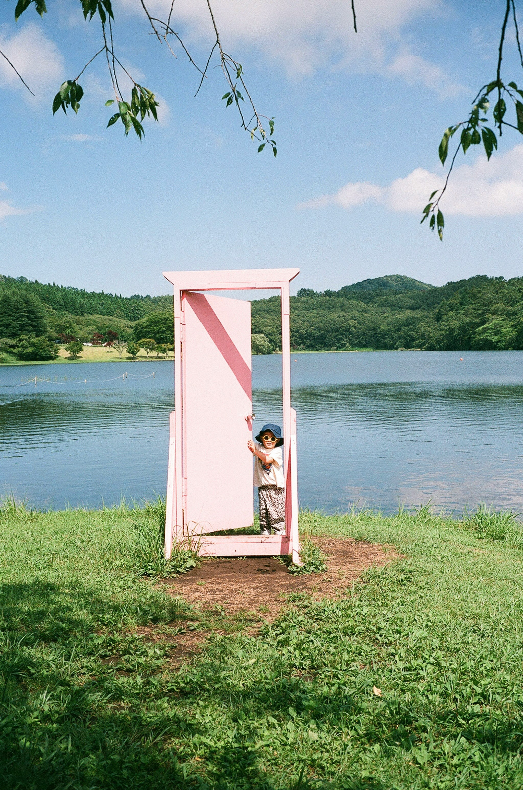 湖畔の芝生に立つピンクのフォトフレーム