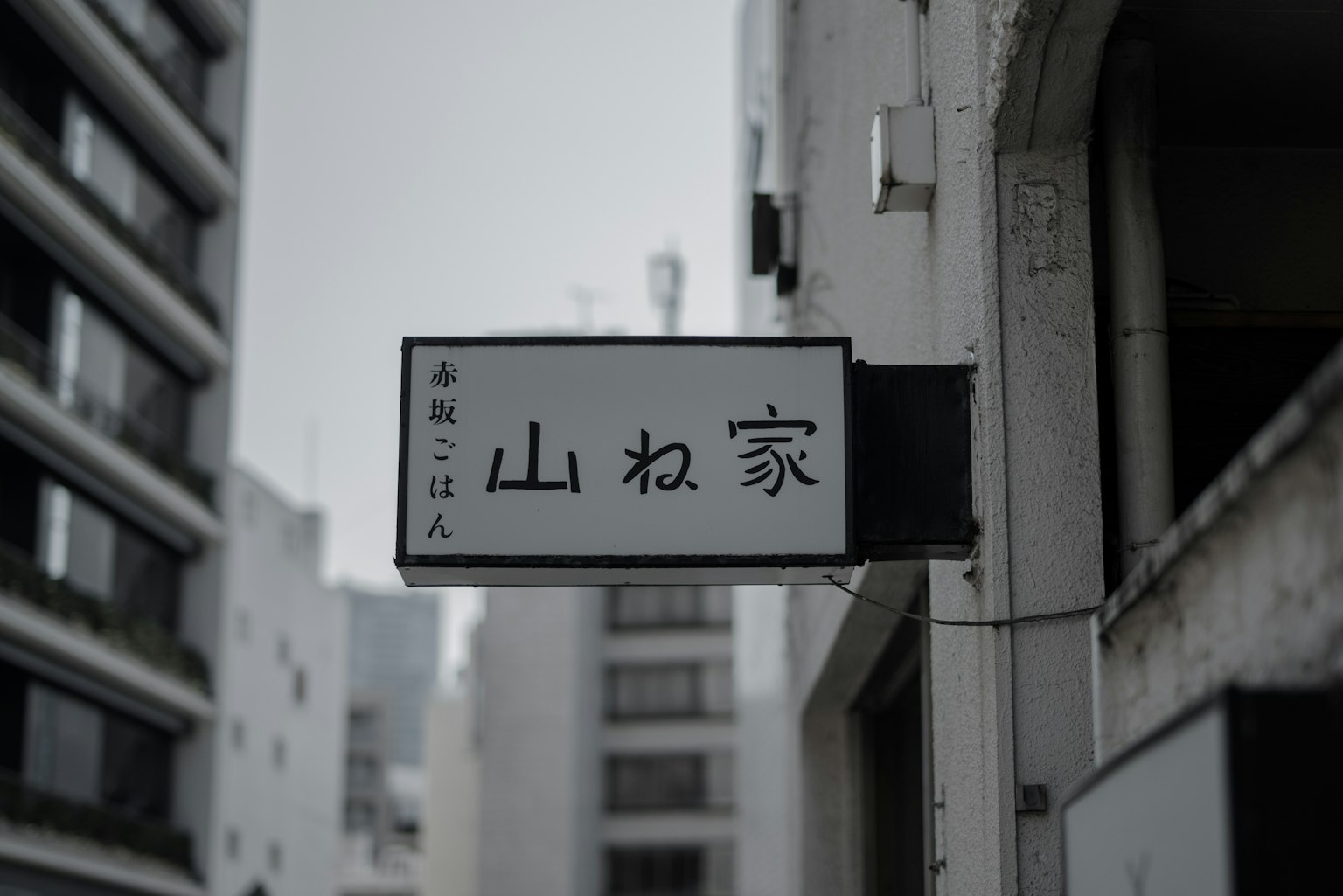 Sign of Yamane House in an urban setting