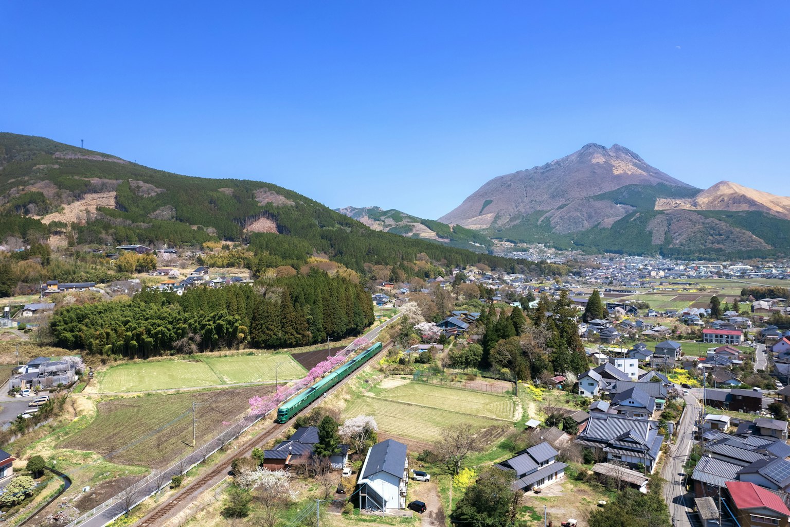 Vue pittoresque de la préfecture d'Oita avec un paysage rural et des montagnes sous un ciel bleu dégagé