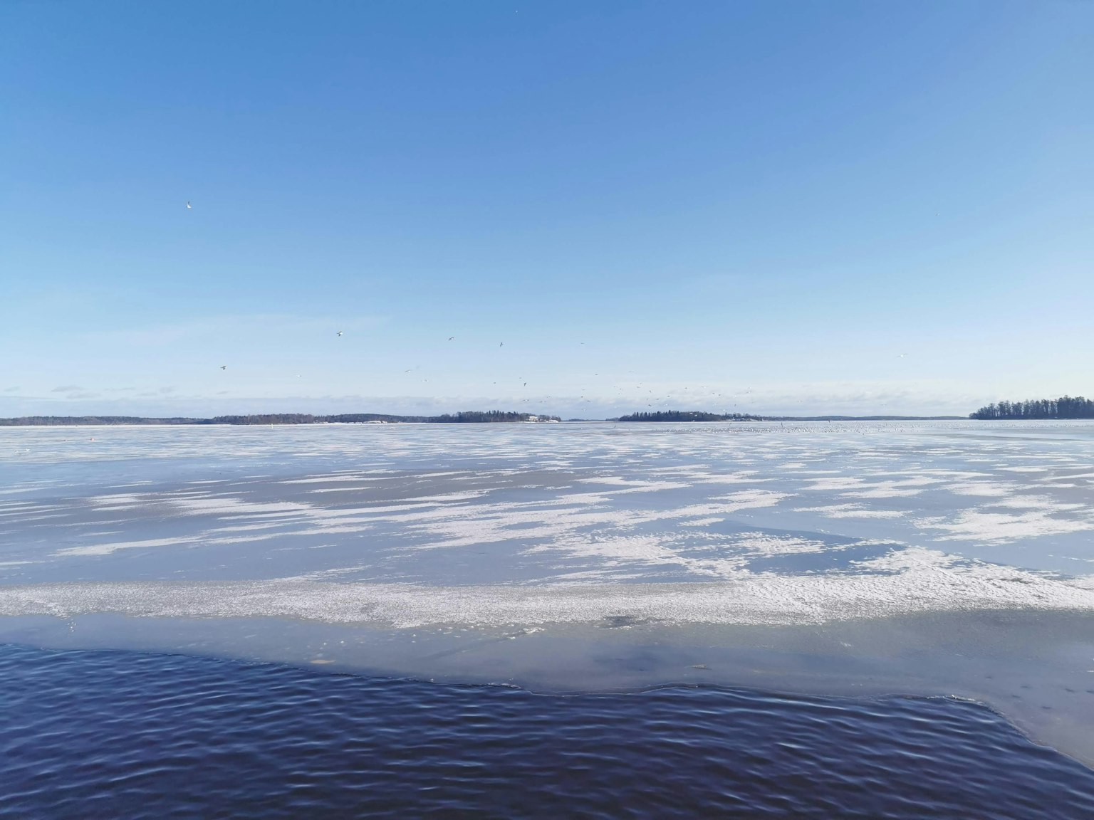 Lac gelé avec des plaques de glace sous un ciel bleu clair