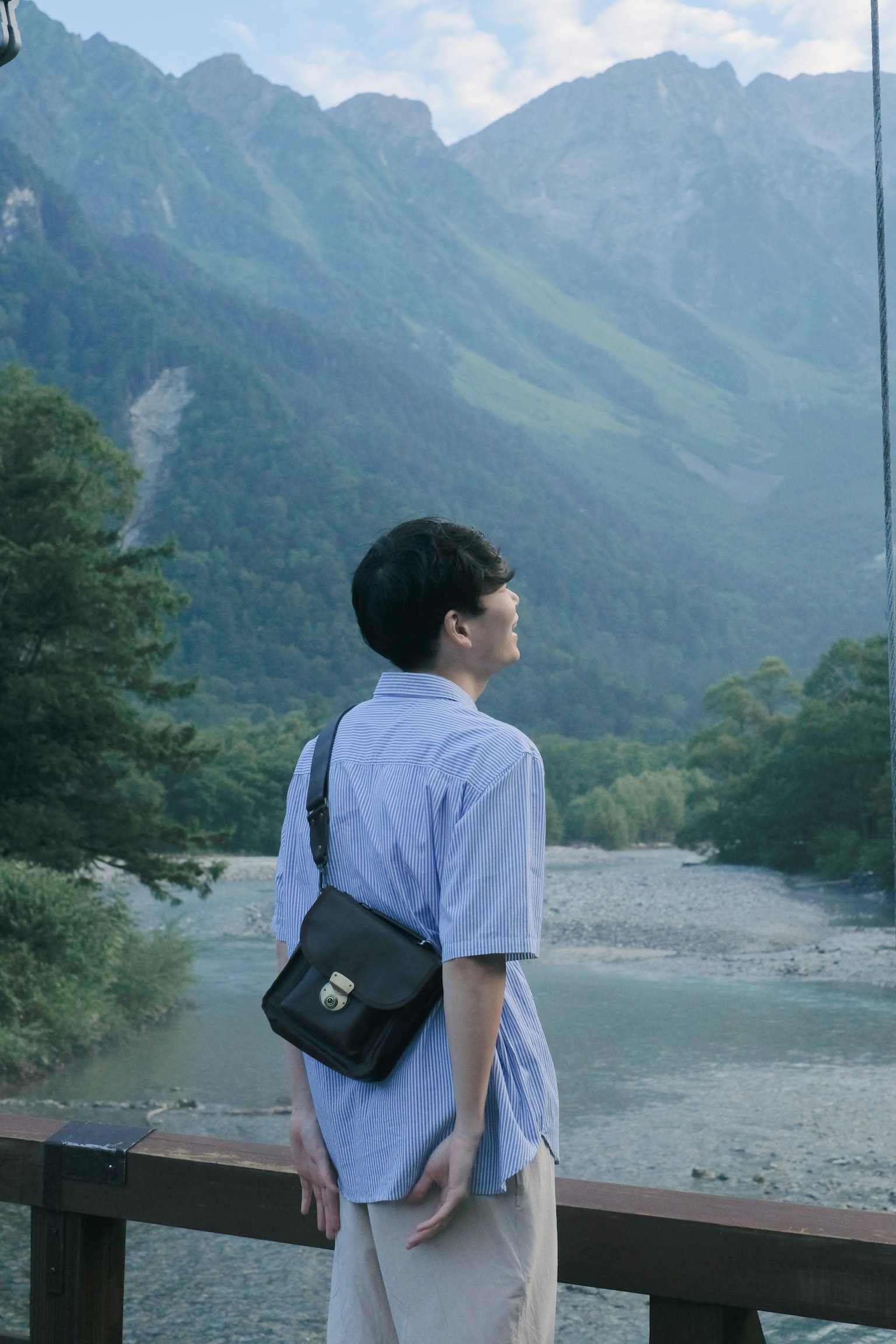 Junge Person mit Bergen im Hintergrund ruhiger Moment in der Natur