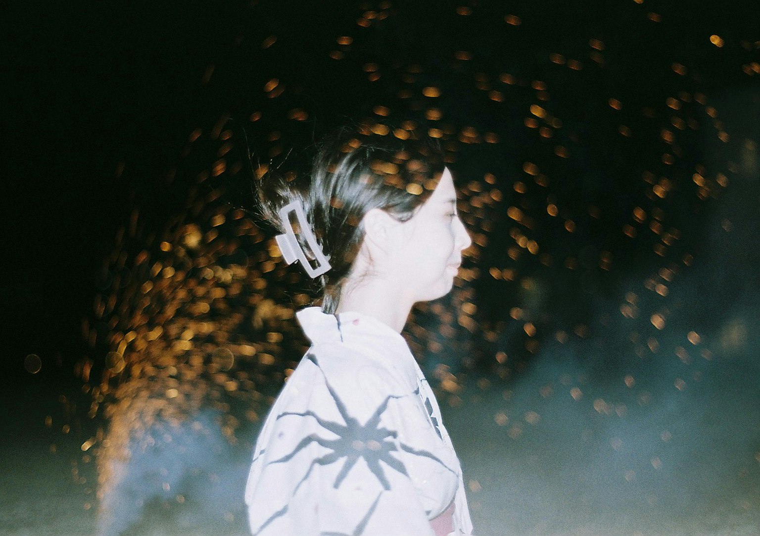 穿著和服的女性側面與背景中的火花
