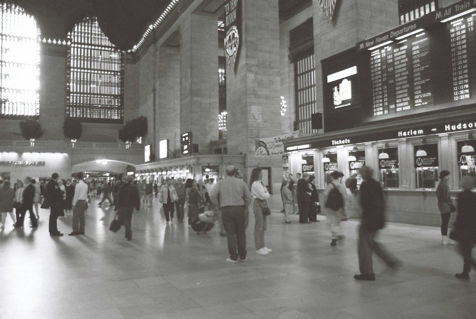 Ảnh đen trắng về nội thất nhà ga Grand Central với mọi người đi lại và cửa sổ sáng