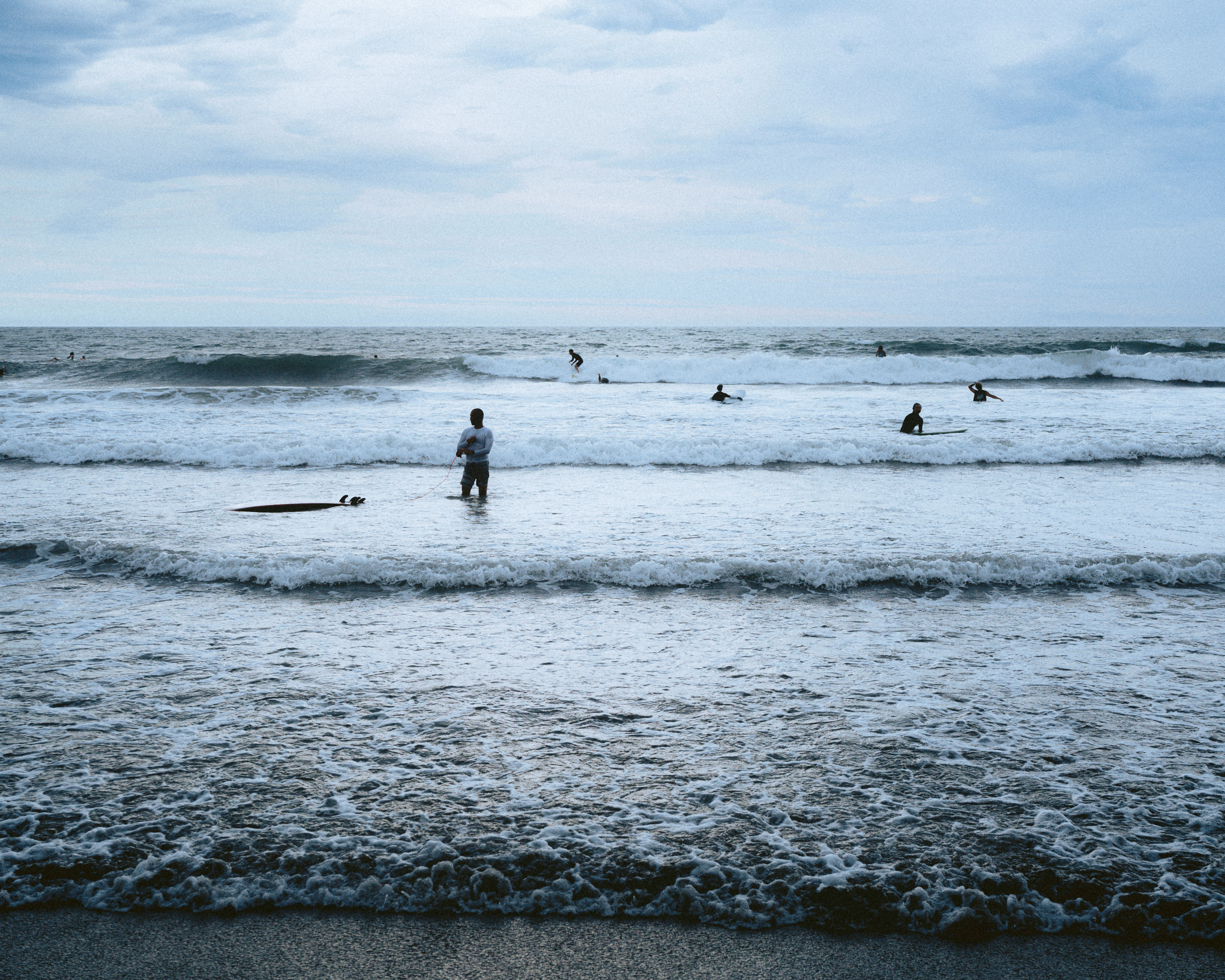 波打ち際で遊ぶ人々のある海辺の風景