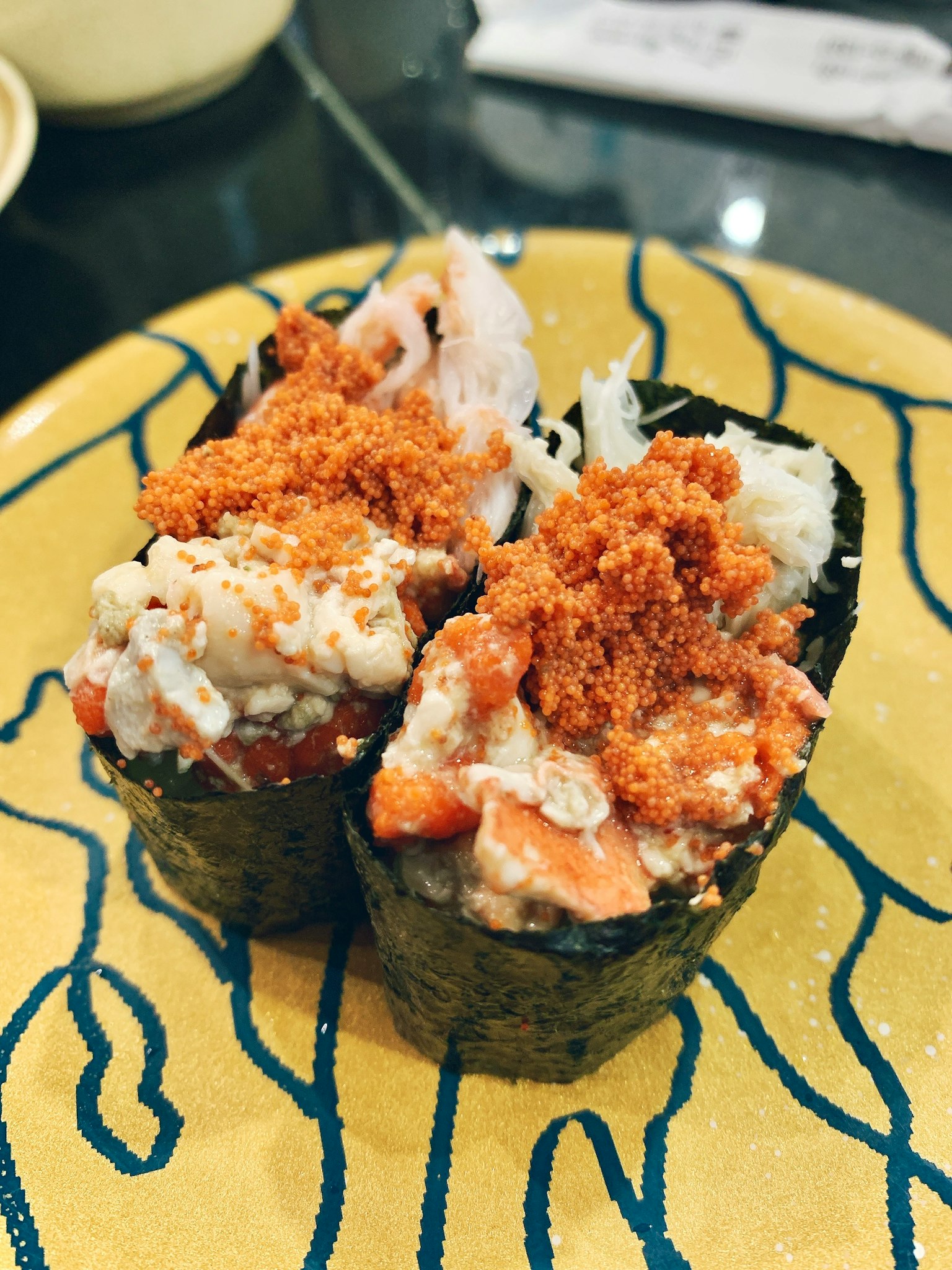 Rollos de sushi con cobertura en un plato amarillo