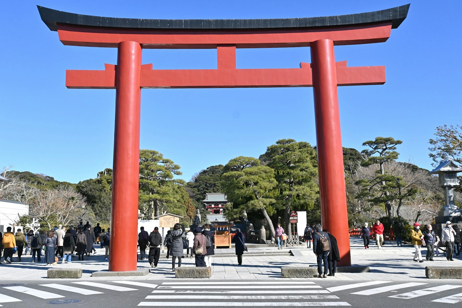 Mọi người đi bộ trước cổng torii đỏ lớn dưới bầu trời xanh trong
