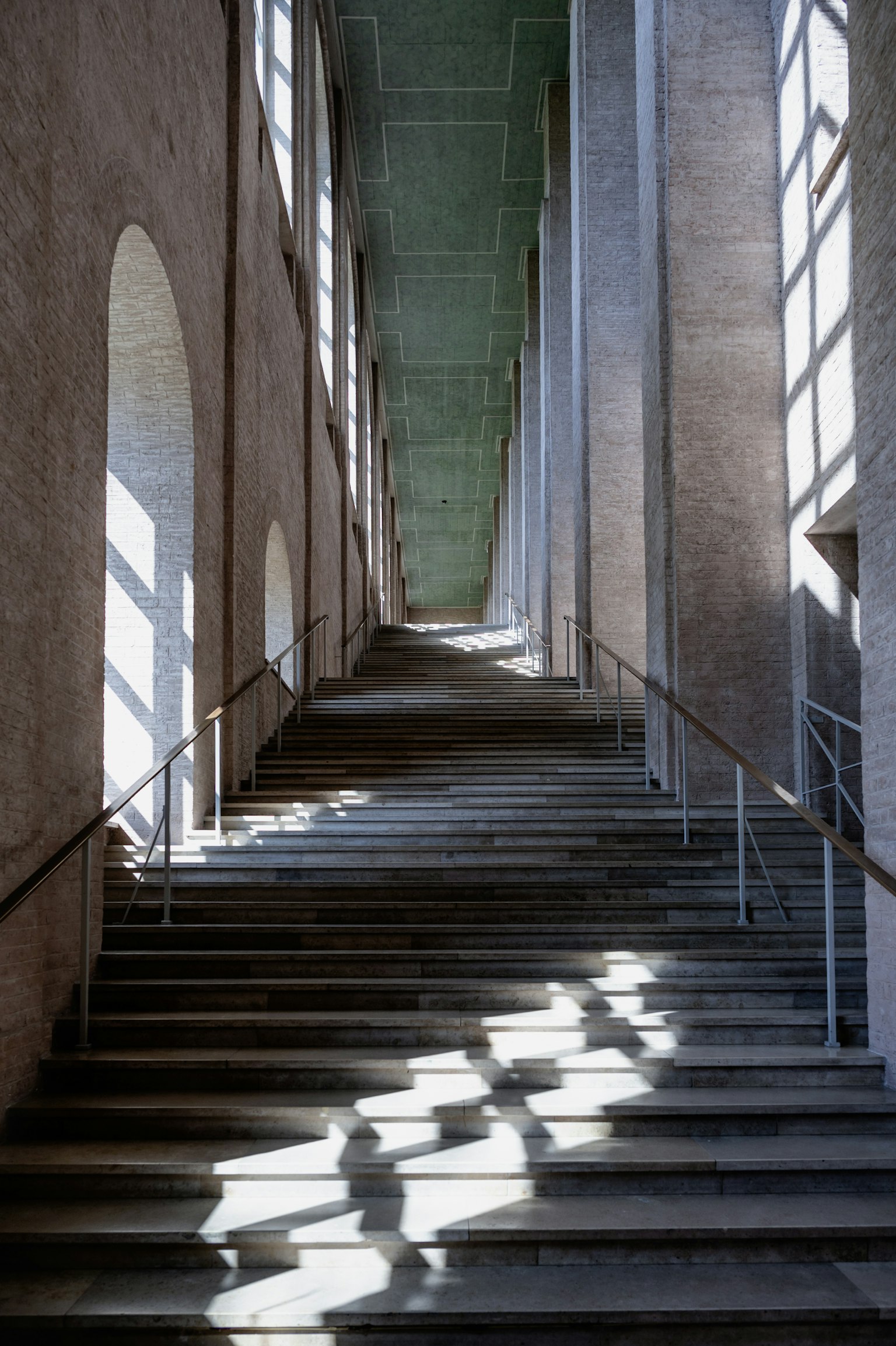 Intérieur d'un bâtiment avec un escalier éclairé par la lumière et les ombres