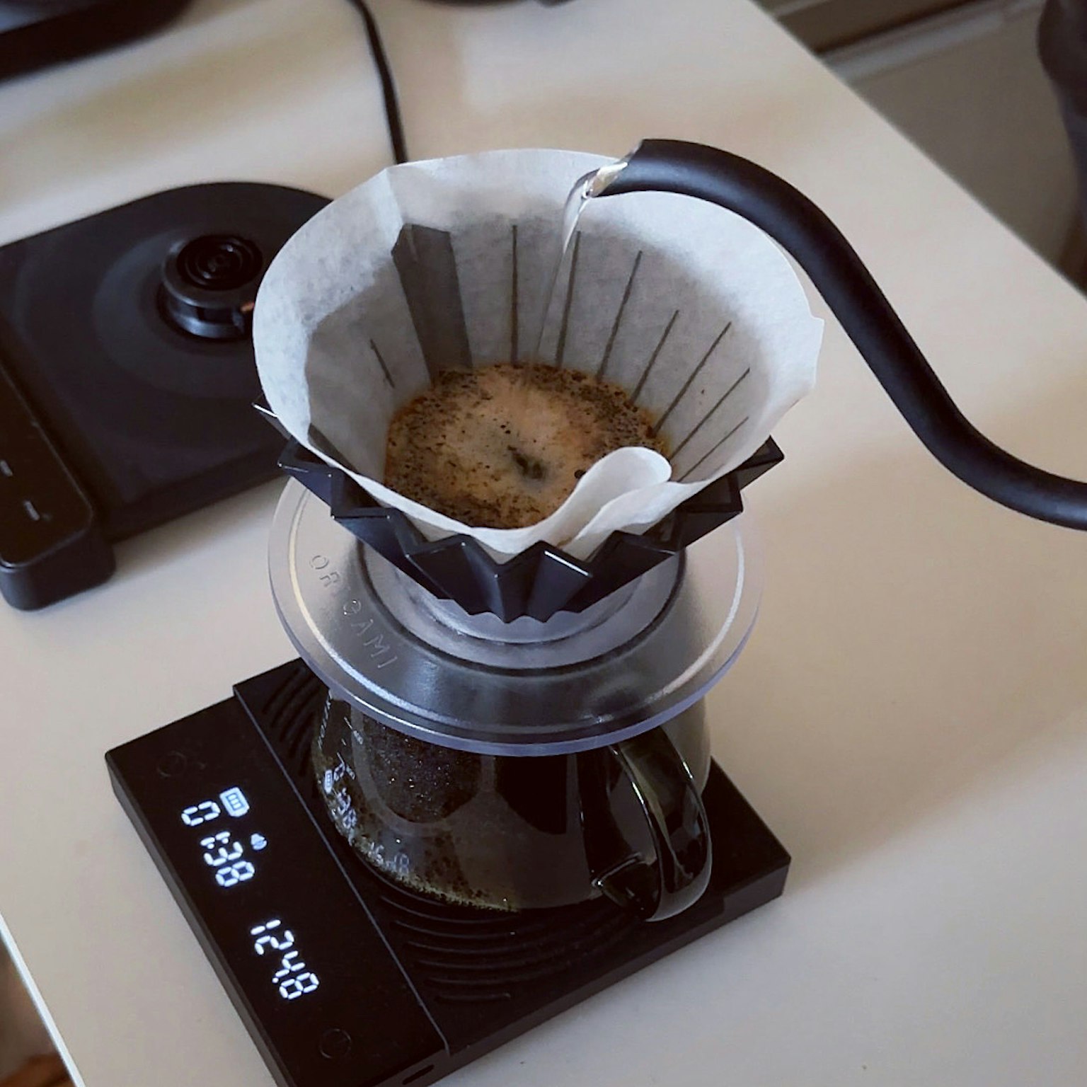Image d'un filtre à café avec du café en cours d'infusion sur une balance avec un thermomètre