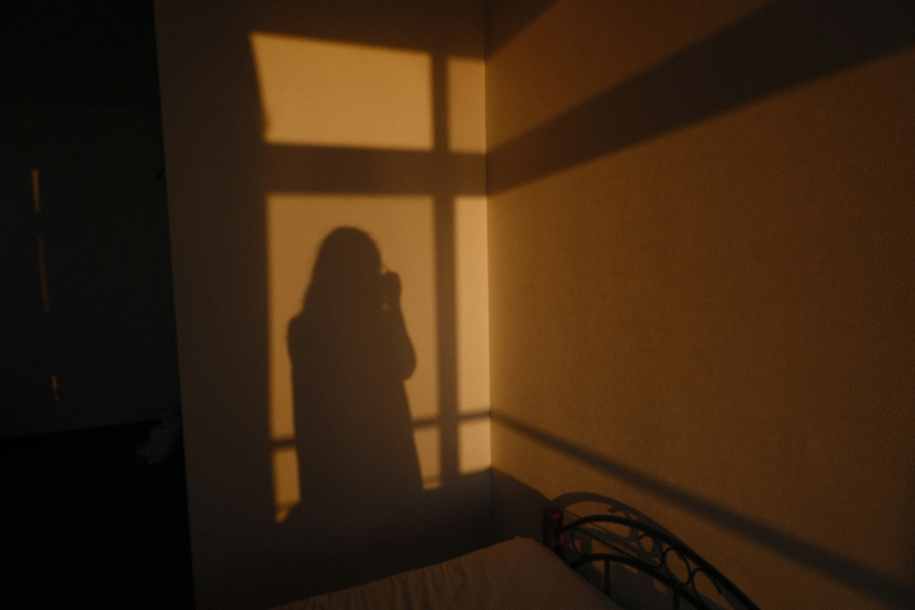 朝の光が差し込む室内で影になる人物