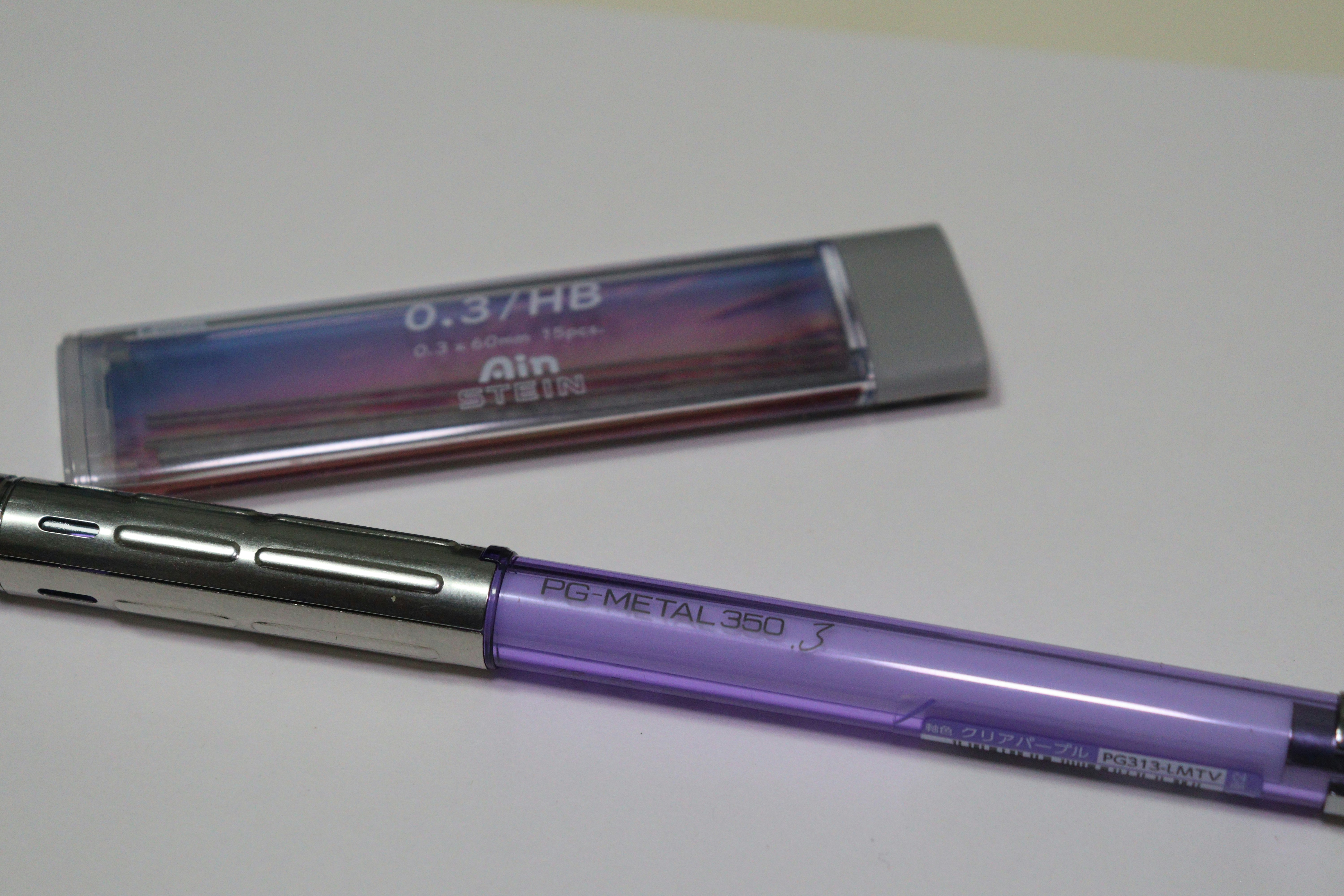 purple pen and eraser-like stationery arranged on a desk still life