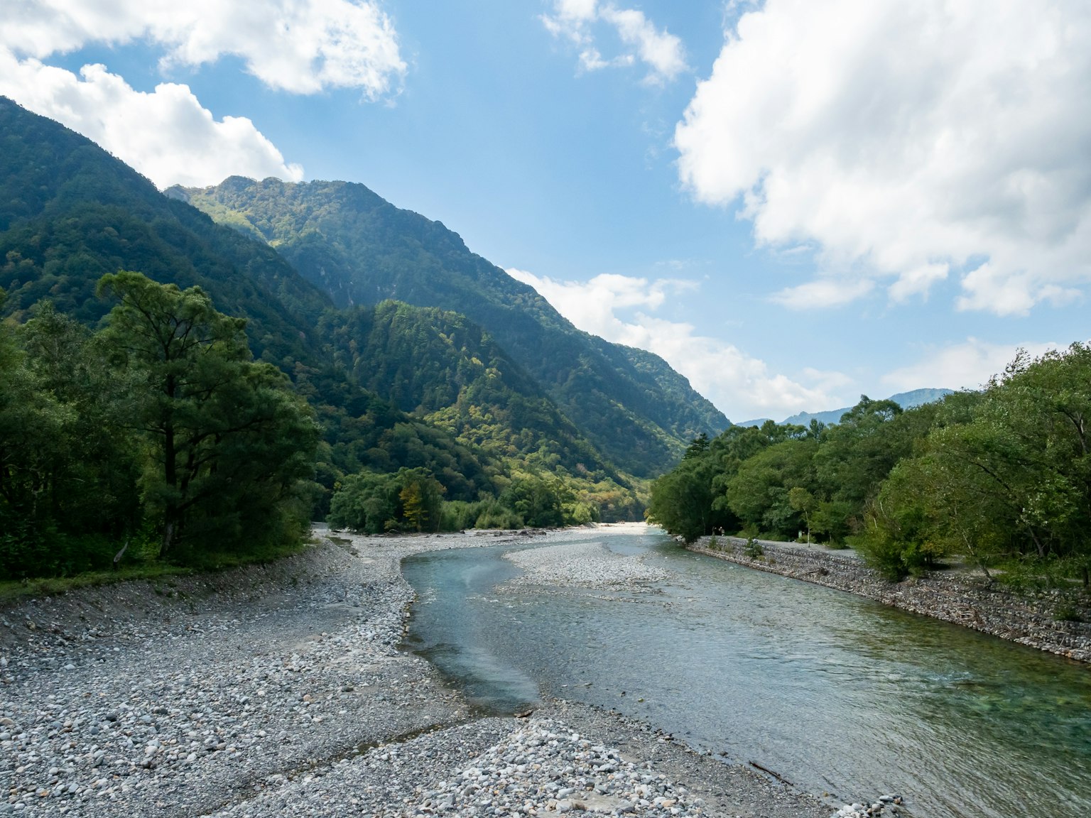 Malersches Flusslandschaft umgeben von Bergen und üppigem Grün