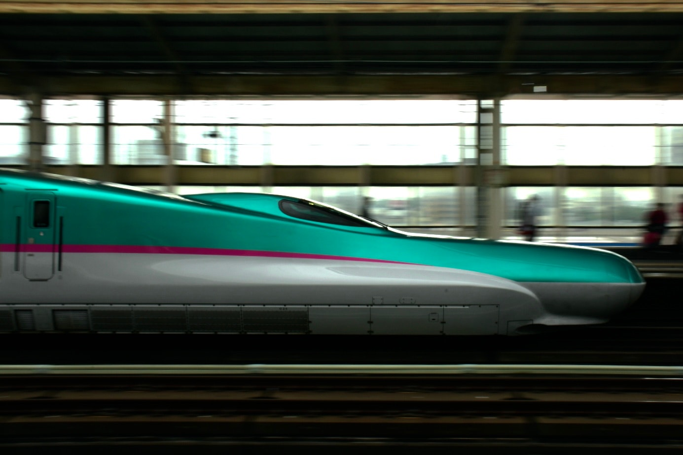 side view of a high-speed train passing on a station platform