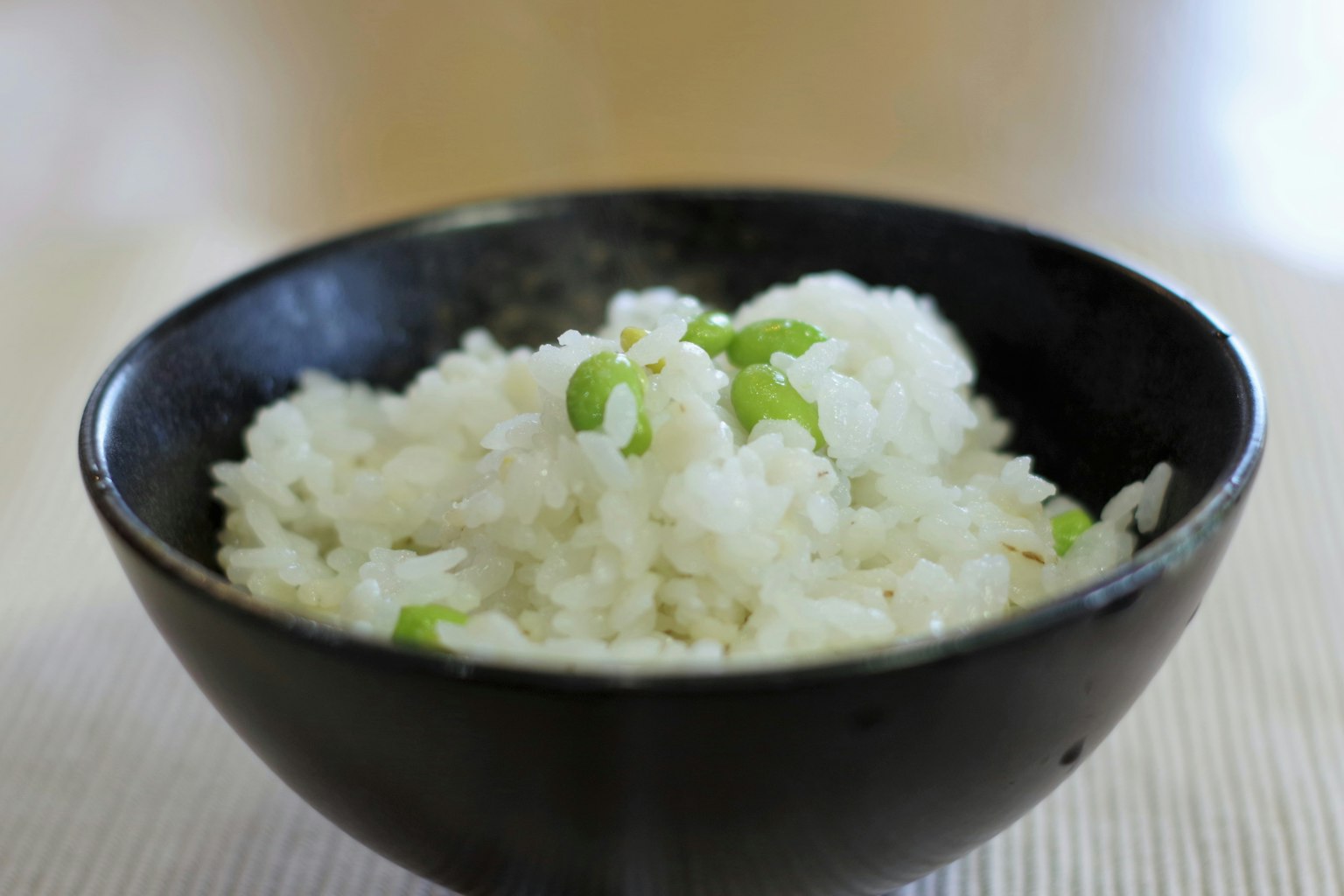 Arroz blanco al vapor con cebollín en un tazón negro