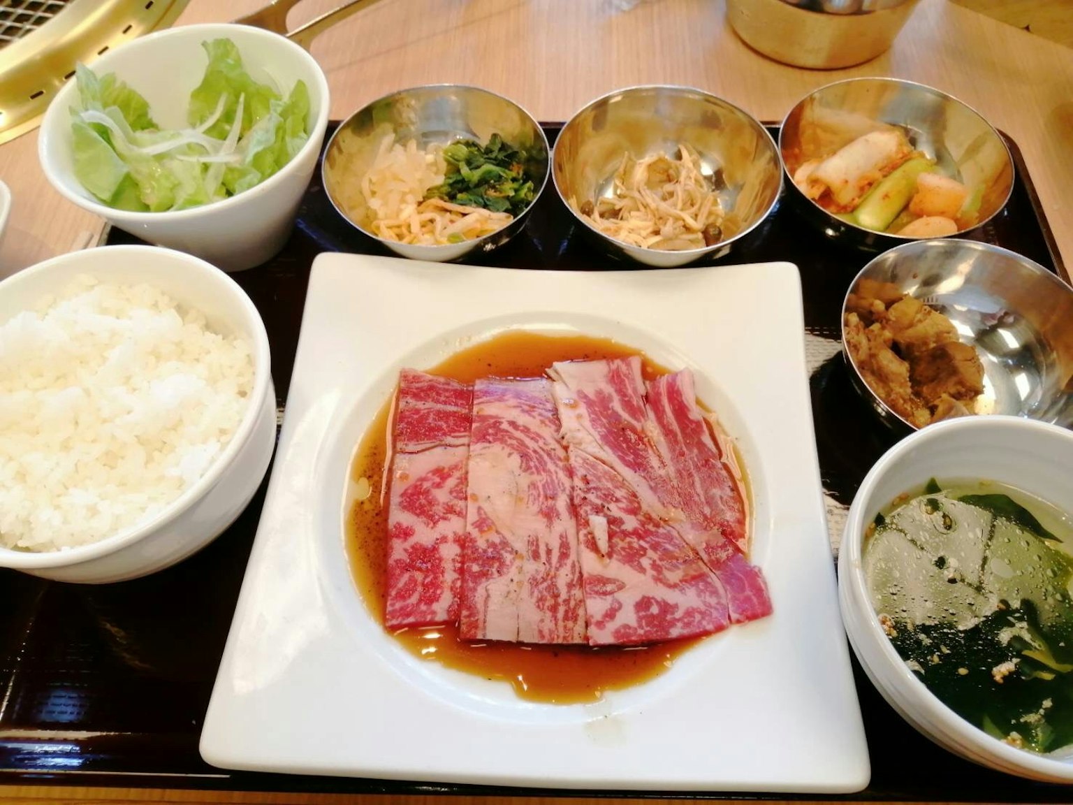 Plato de comida japonesa delicioso con carne cruda y arroz con varios acompañamientos