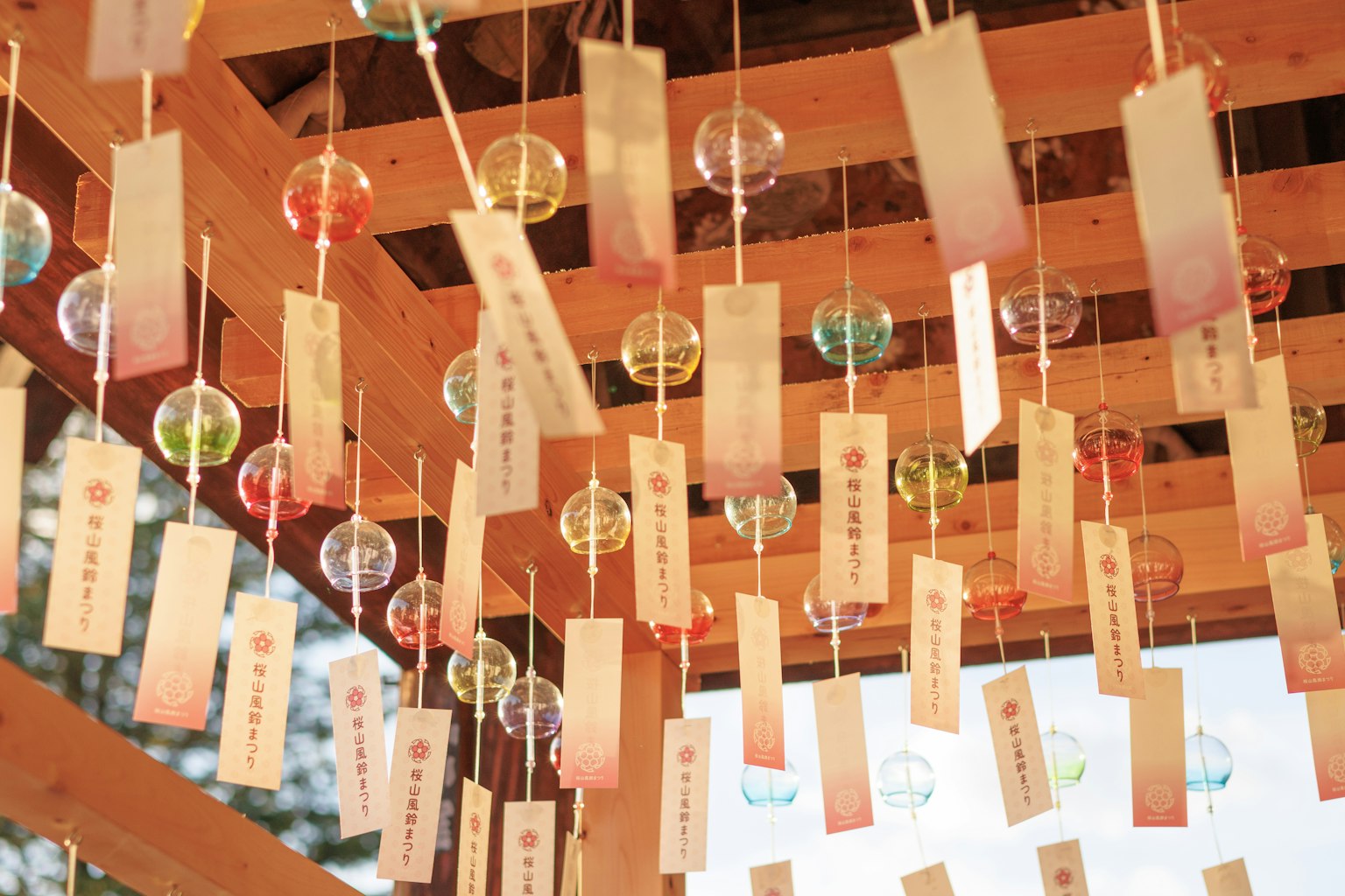 Chuông gió đầy màu sắc và dải trang trí treo từ một cấu trúc gỗ