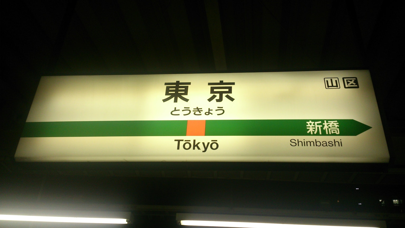 Insegna per la stazione di Tokyo con linea verde e marcatore arancione