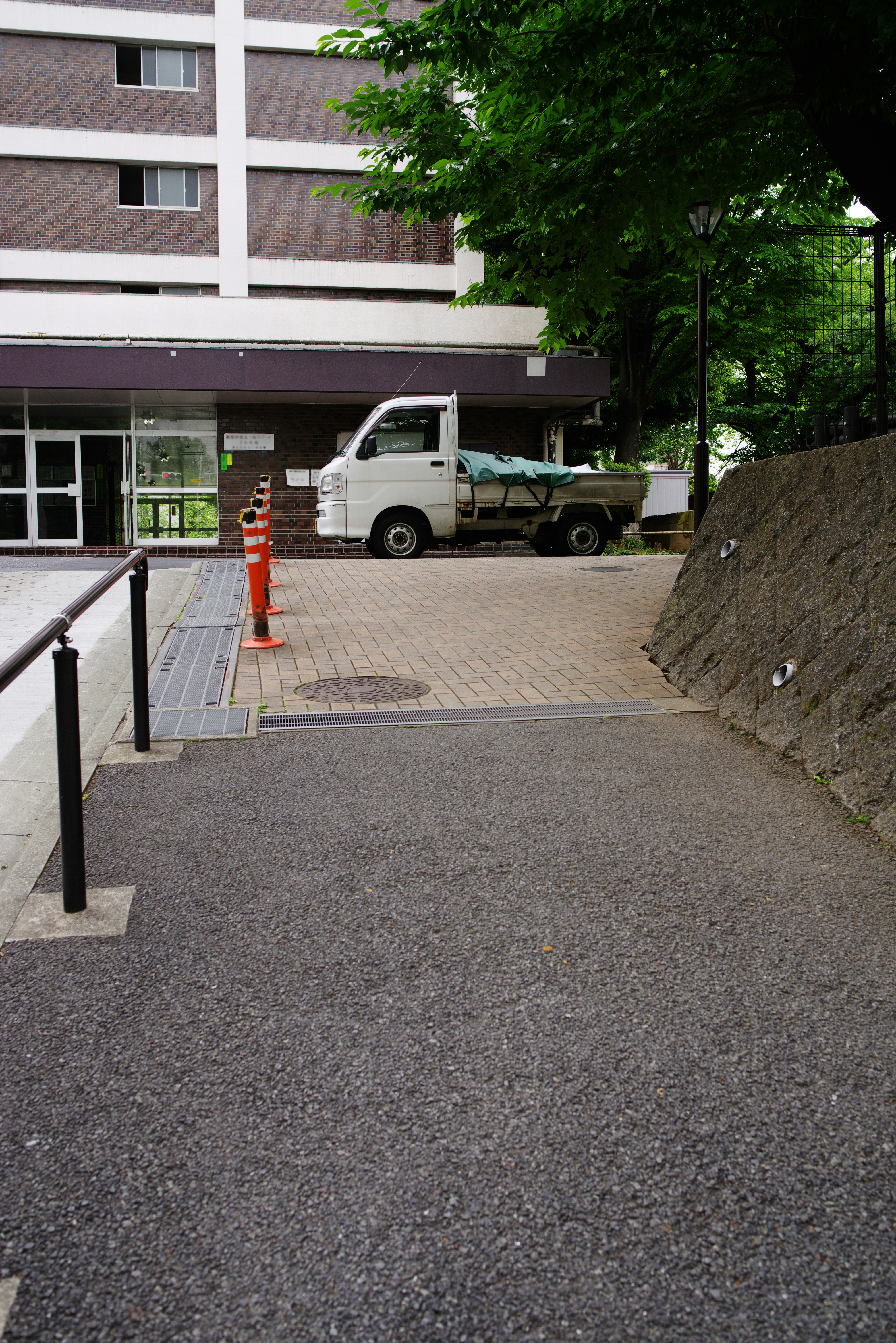 建物の脇の通路に停まる小型トラック