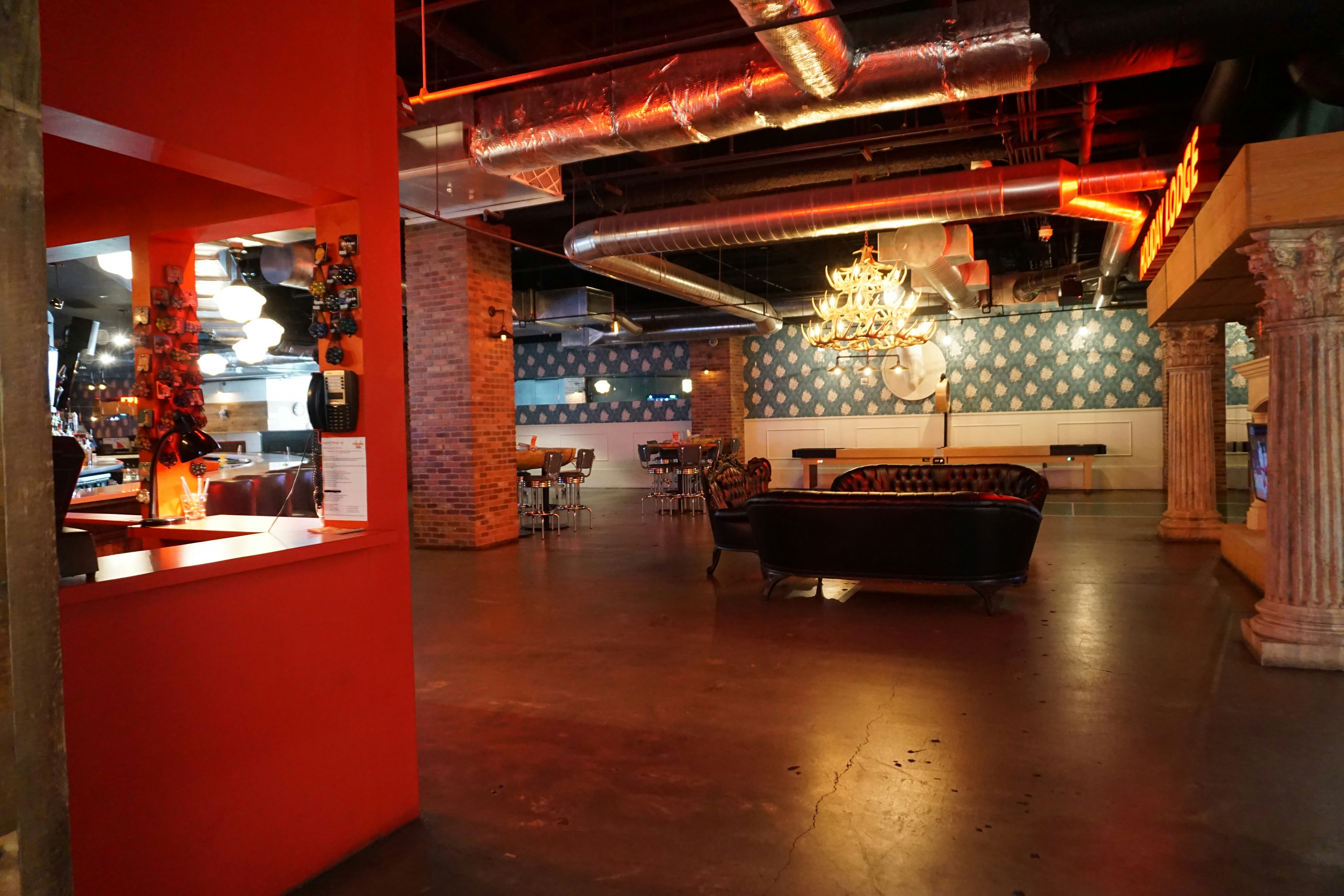 Spacious indoor lounge with brick walls and red pillars