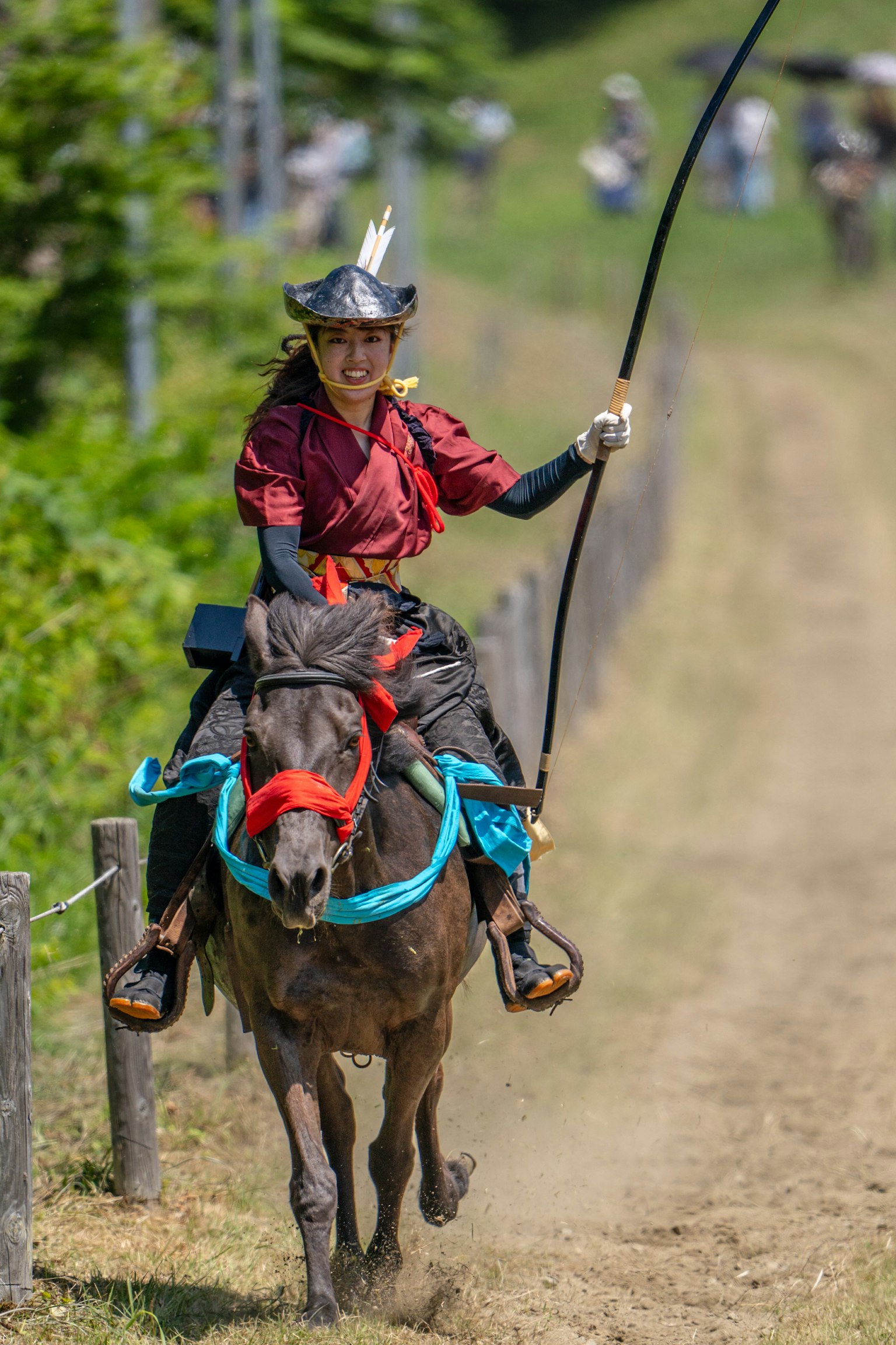Une femme en tenue rouge chevauche un cheval lors d'une compétition