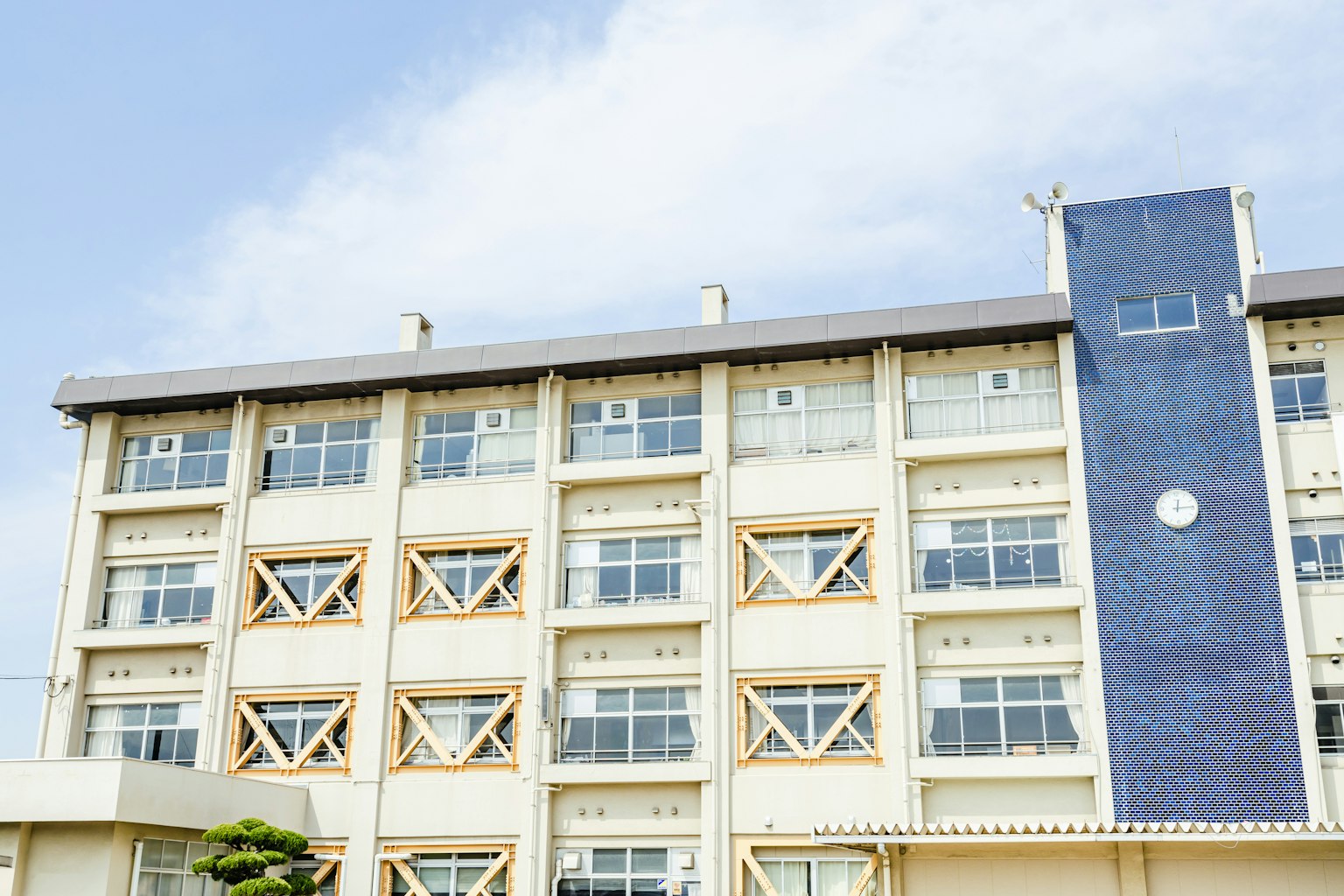 Ngoại thất tòa nhà hiện đại với cửa sổ lớn dưới bầu trời xanh