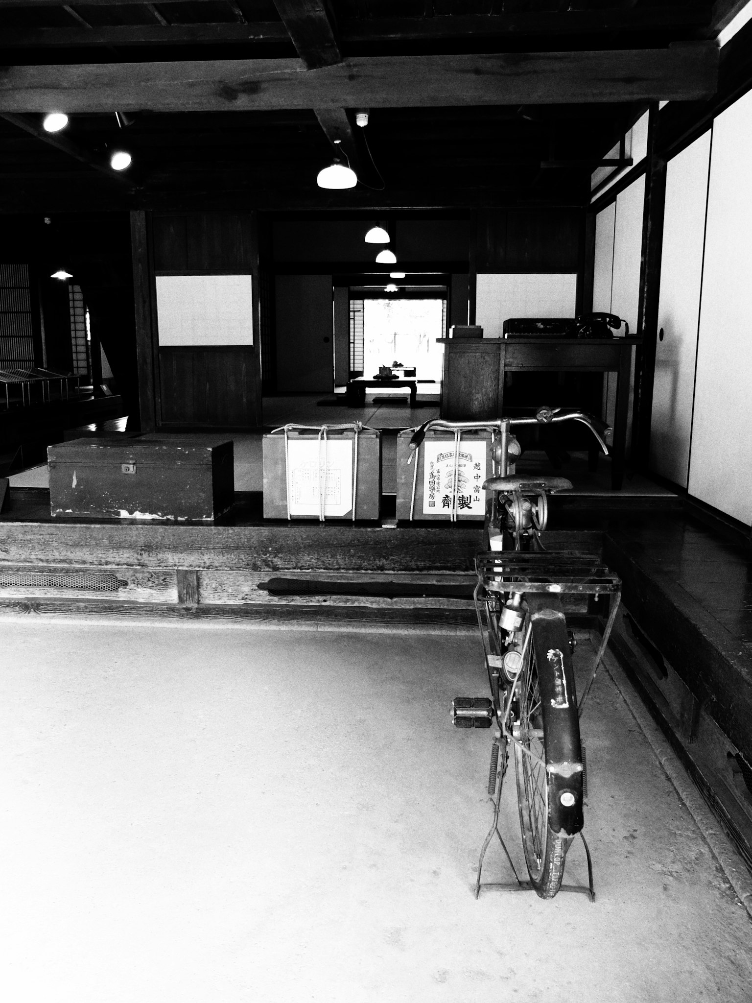 Scène intérieure en noir et blanc avec des meubles en bois et un éclairage traditionnel japonais