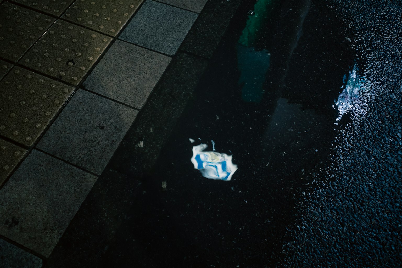 Un morceau de papier blanc dans une flaque sur le trottoir