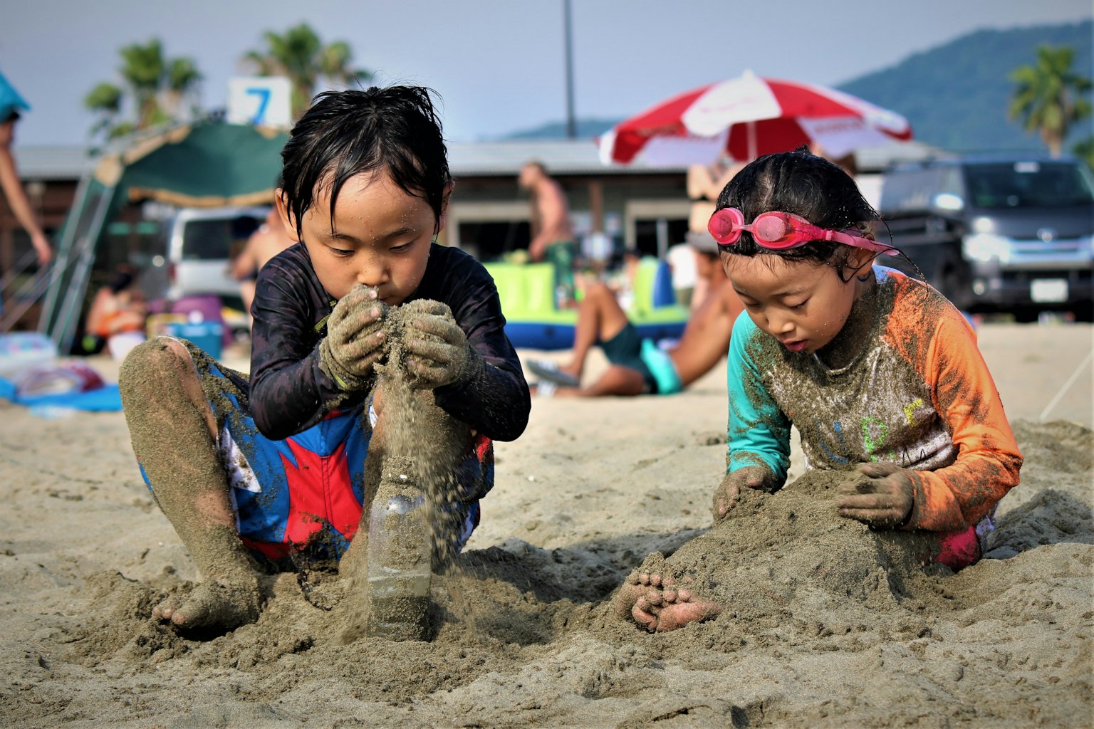 砂遊びを楽しむ二人の子供たち 浜辺で遊んでいる