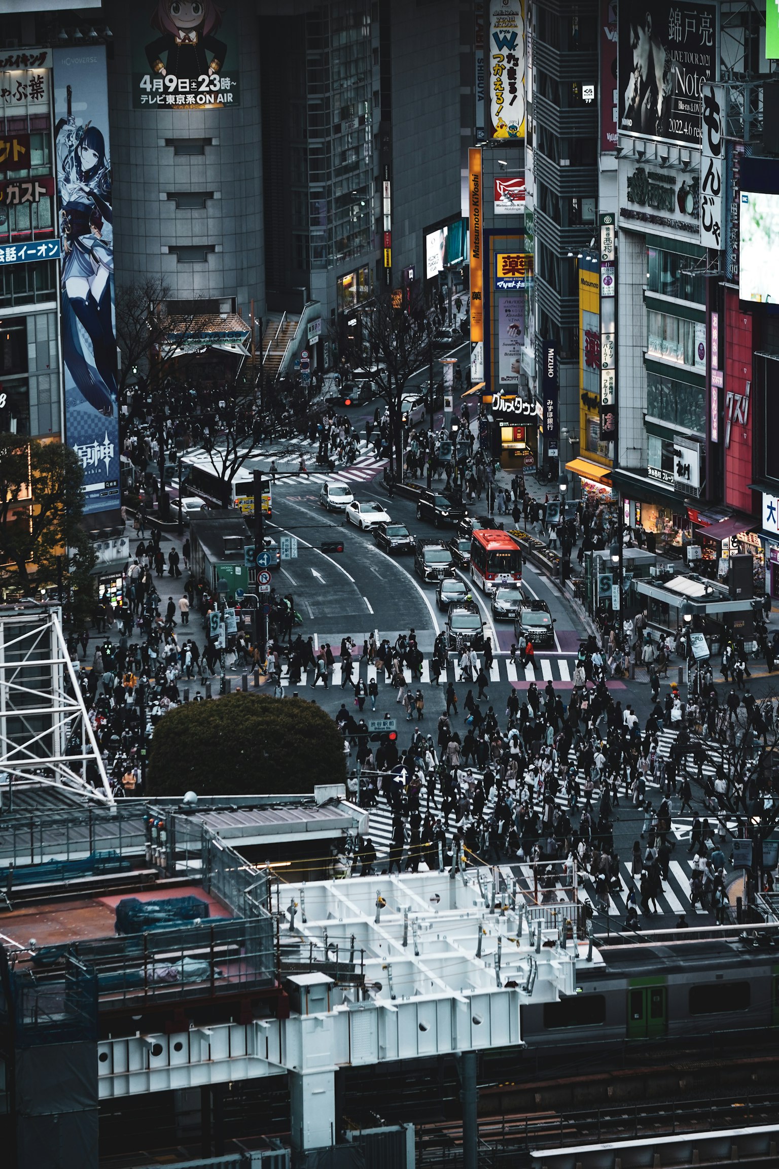 Pemandangan jalan yang ramai di Shibuya dengan kerumunan dan papan iklan neon di malam hari