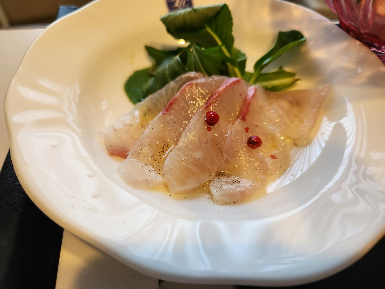 切片魚生與香草裝盤在白色盤子上