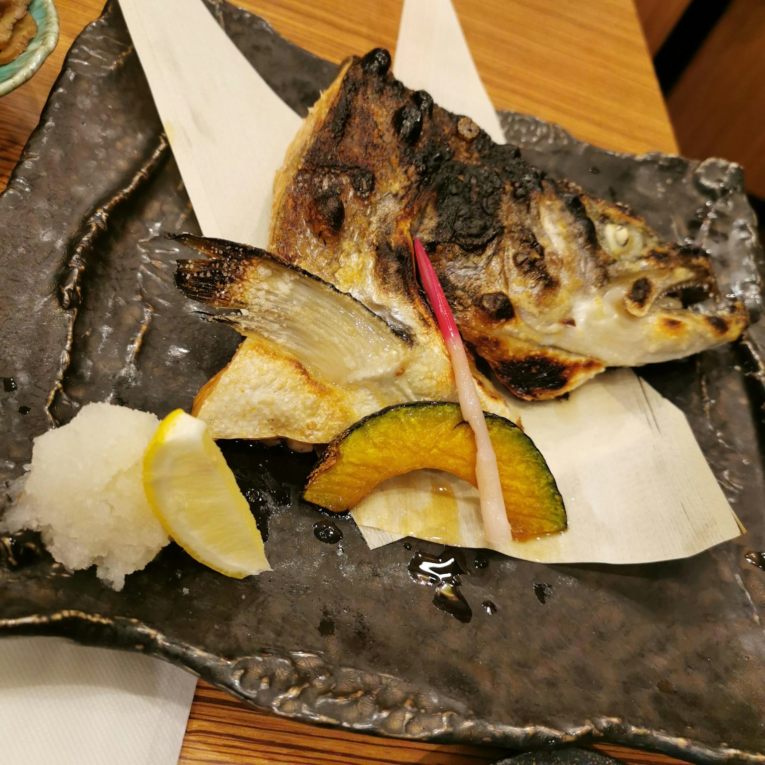 Ikan panggang disajikan dengan sayuran musiman dan hiasan