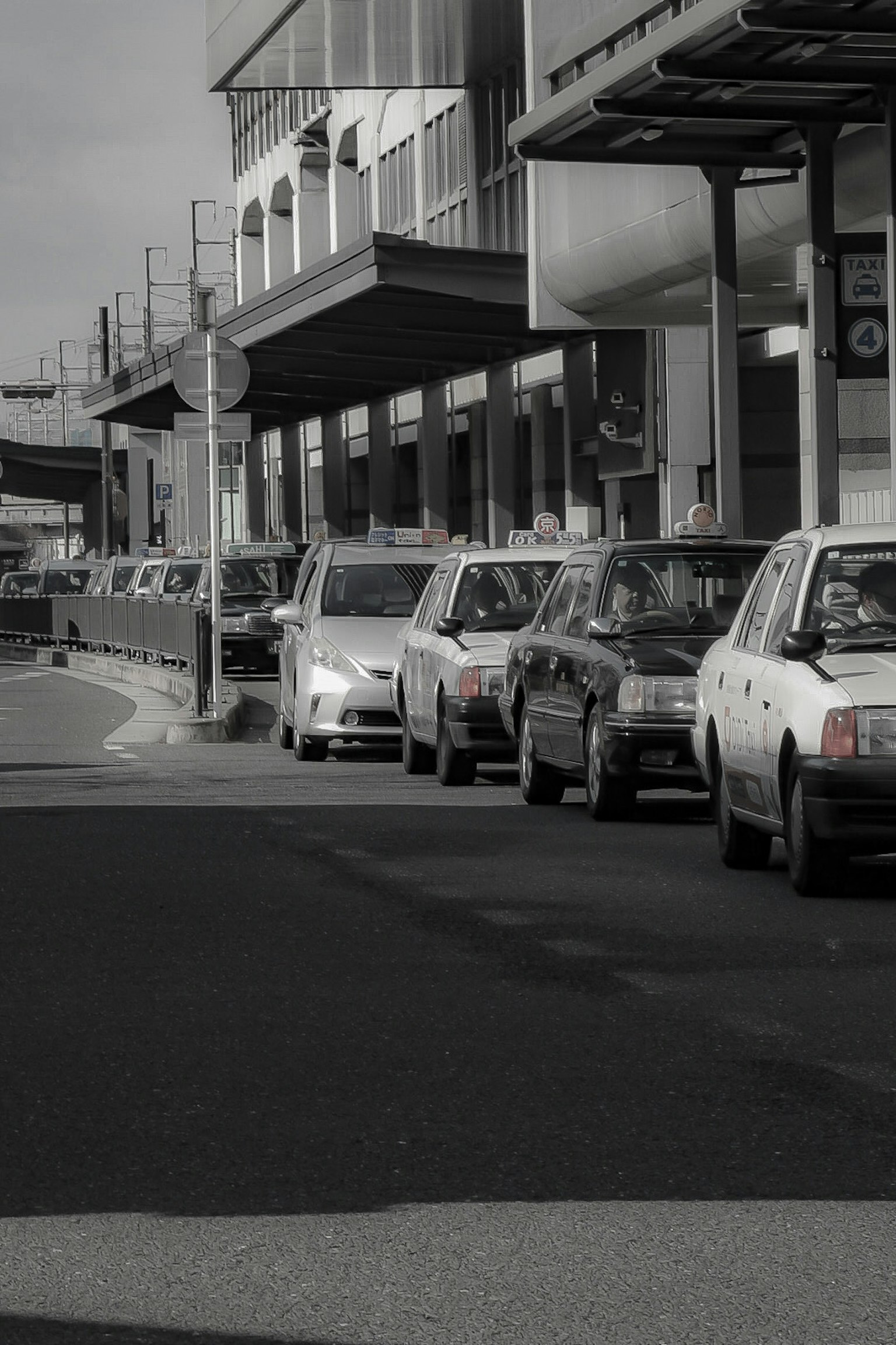 Scena di strada in bianco e nero con auto parcheggiate e edifici