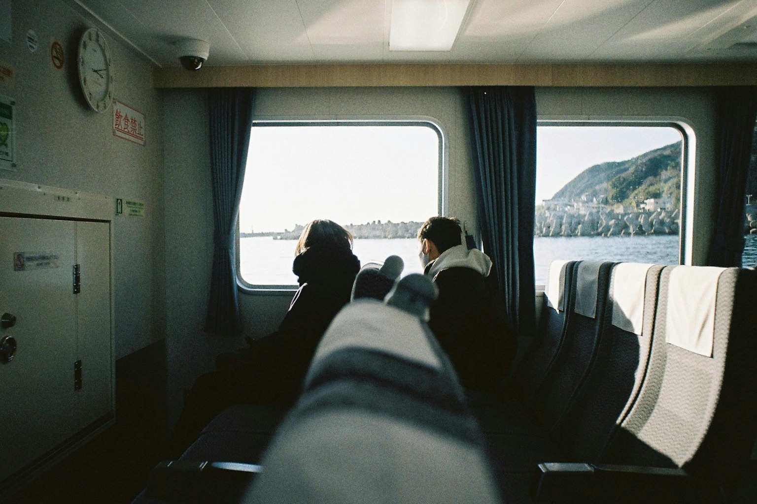 Intérieur d'un ferry avec deux passagers assis près de la fenêtre