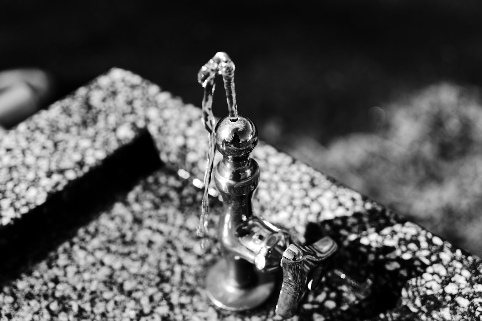 一小個金屬水壺雕塑，背景為黑白色