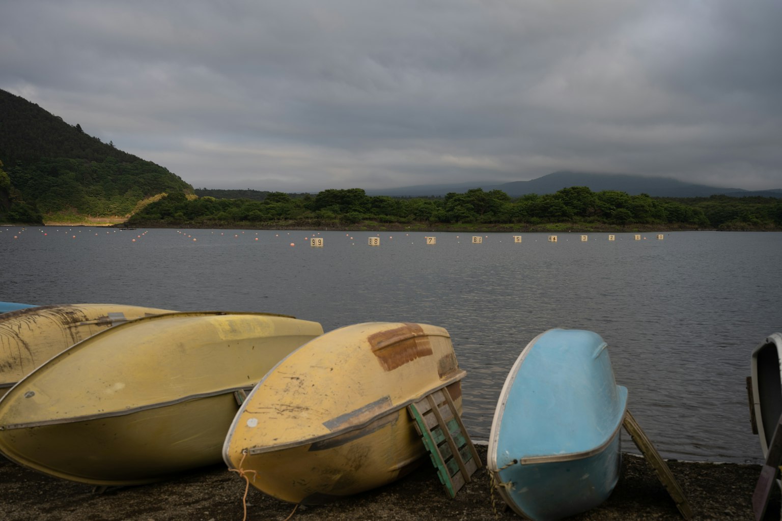 Bateaux colorés près d'un lac calme sous un ciel nuageux