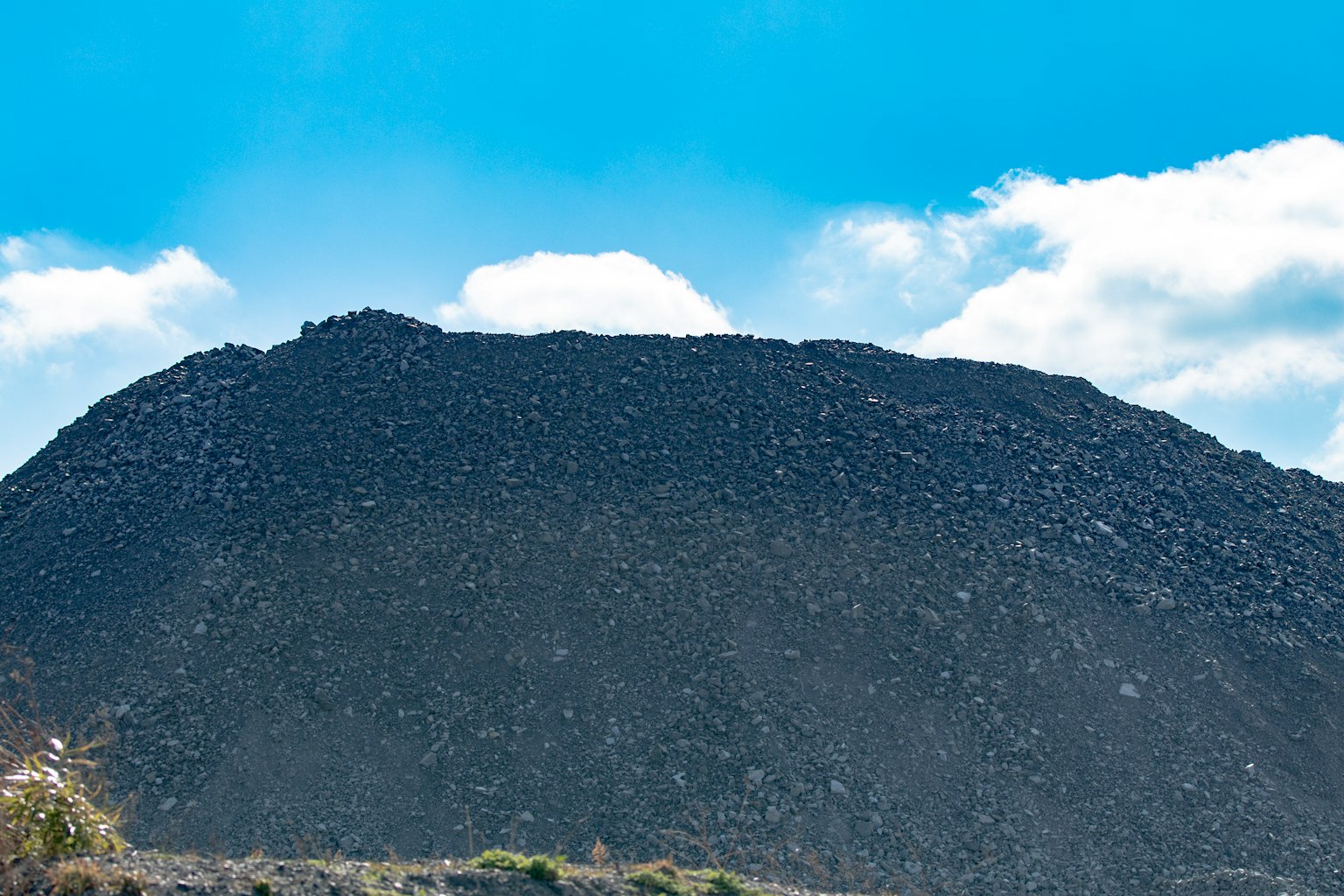 Un paisaje de montaña negra bajo un cielo azul