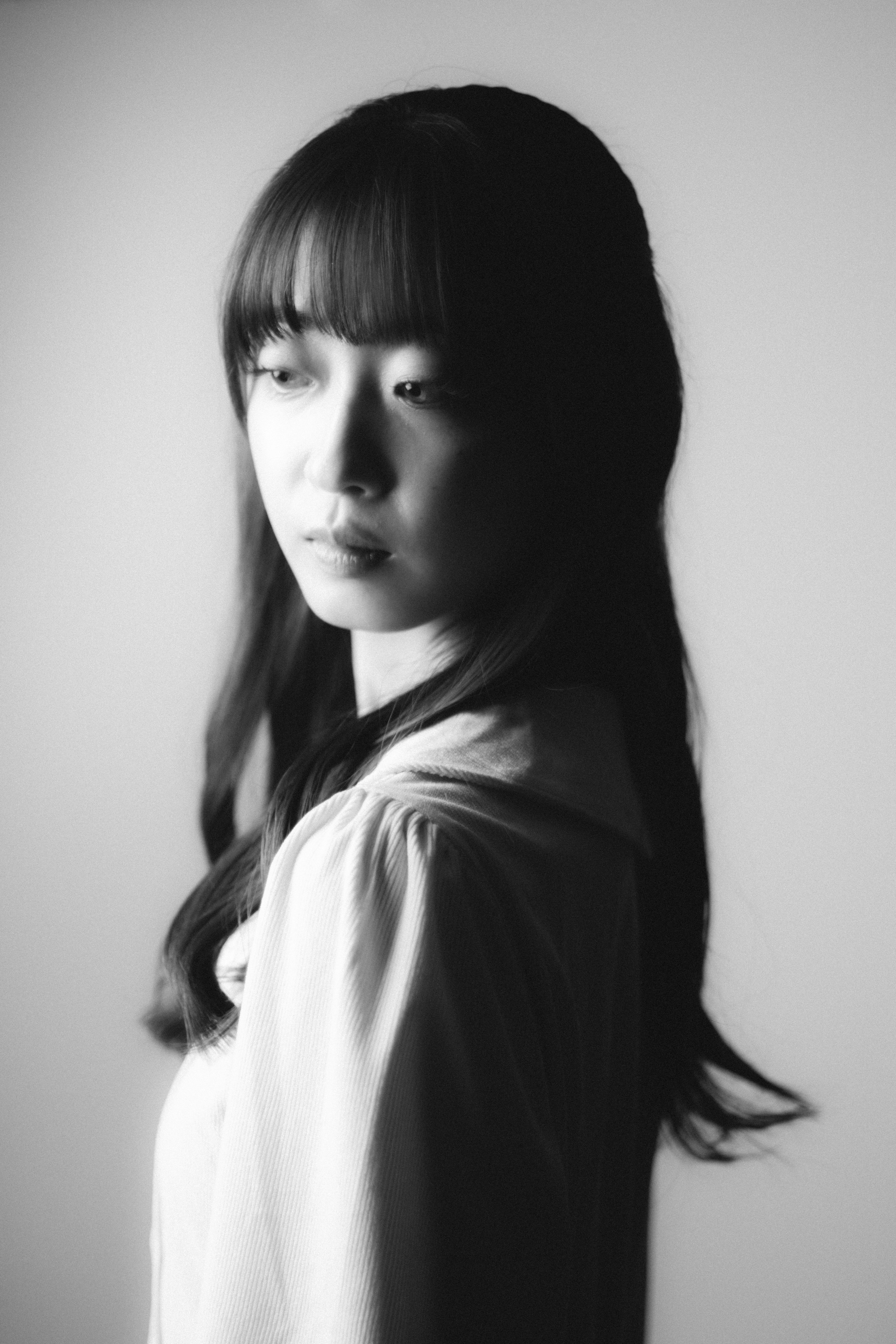 side-profile portrait of a woman against a white background