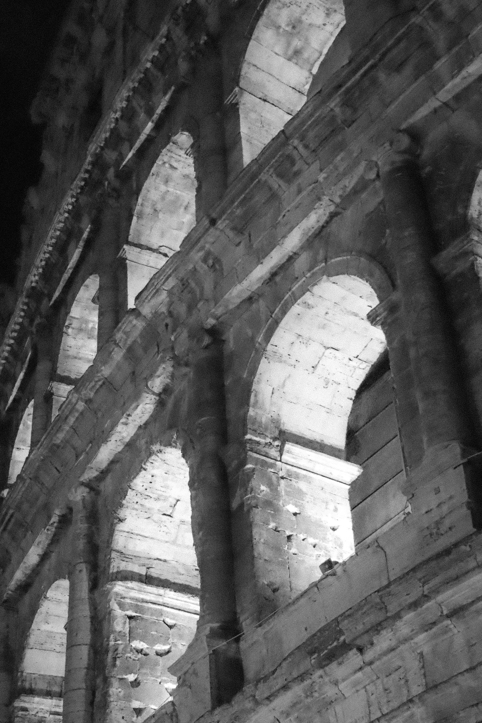 Vue latérale du Colisée de nuit mettant en valeur les arches et la structure en pierre