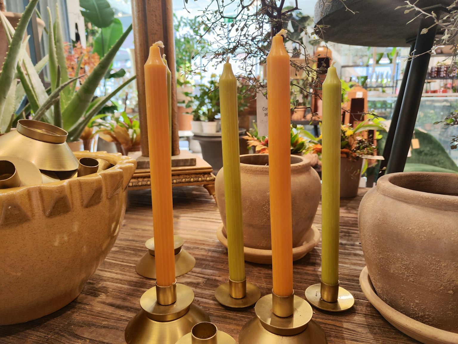 Bougies colorées placées dans des bougeoirs dorés dans un cadre intérieur chaleureux