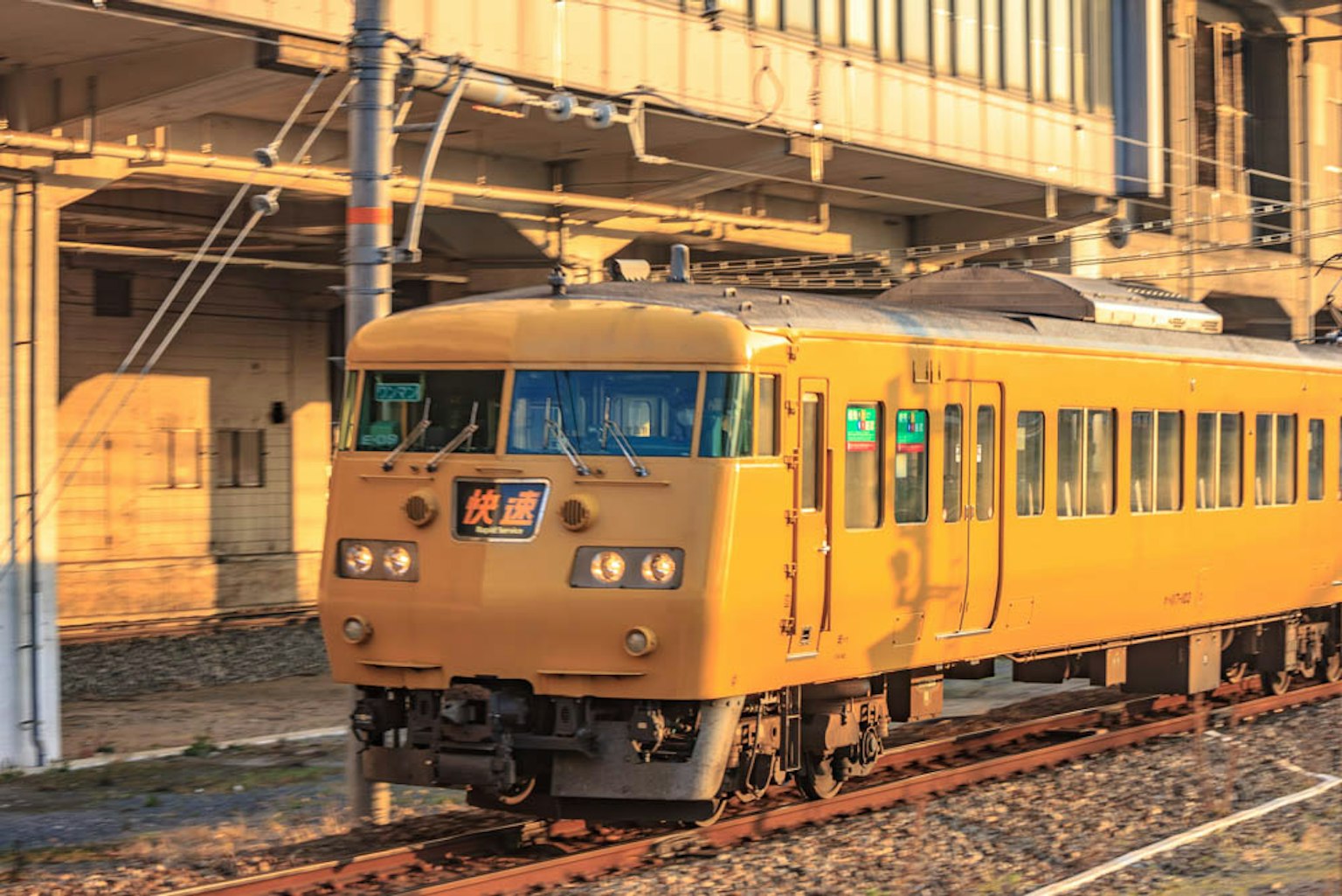 รถไฟสีเหลืองจอดที่สถานีในยามพระอาทิตย์ตก