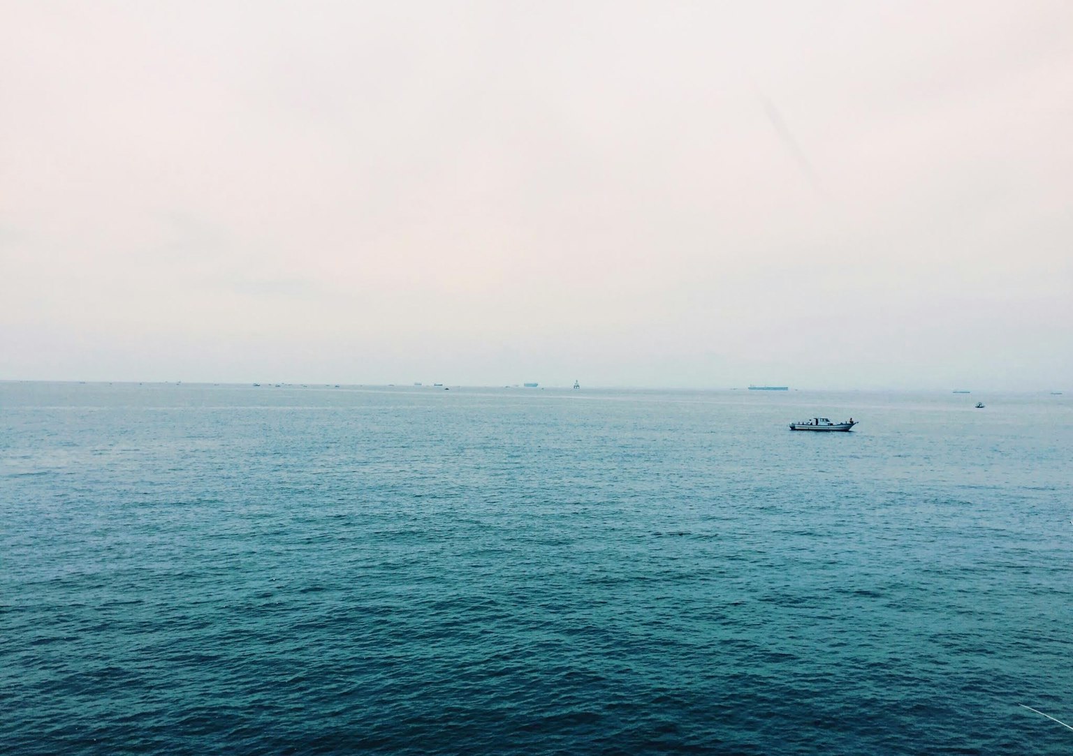 Mer calme avec un ciel légèrement nuageux un petit bateau flottant