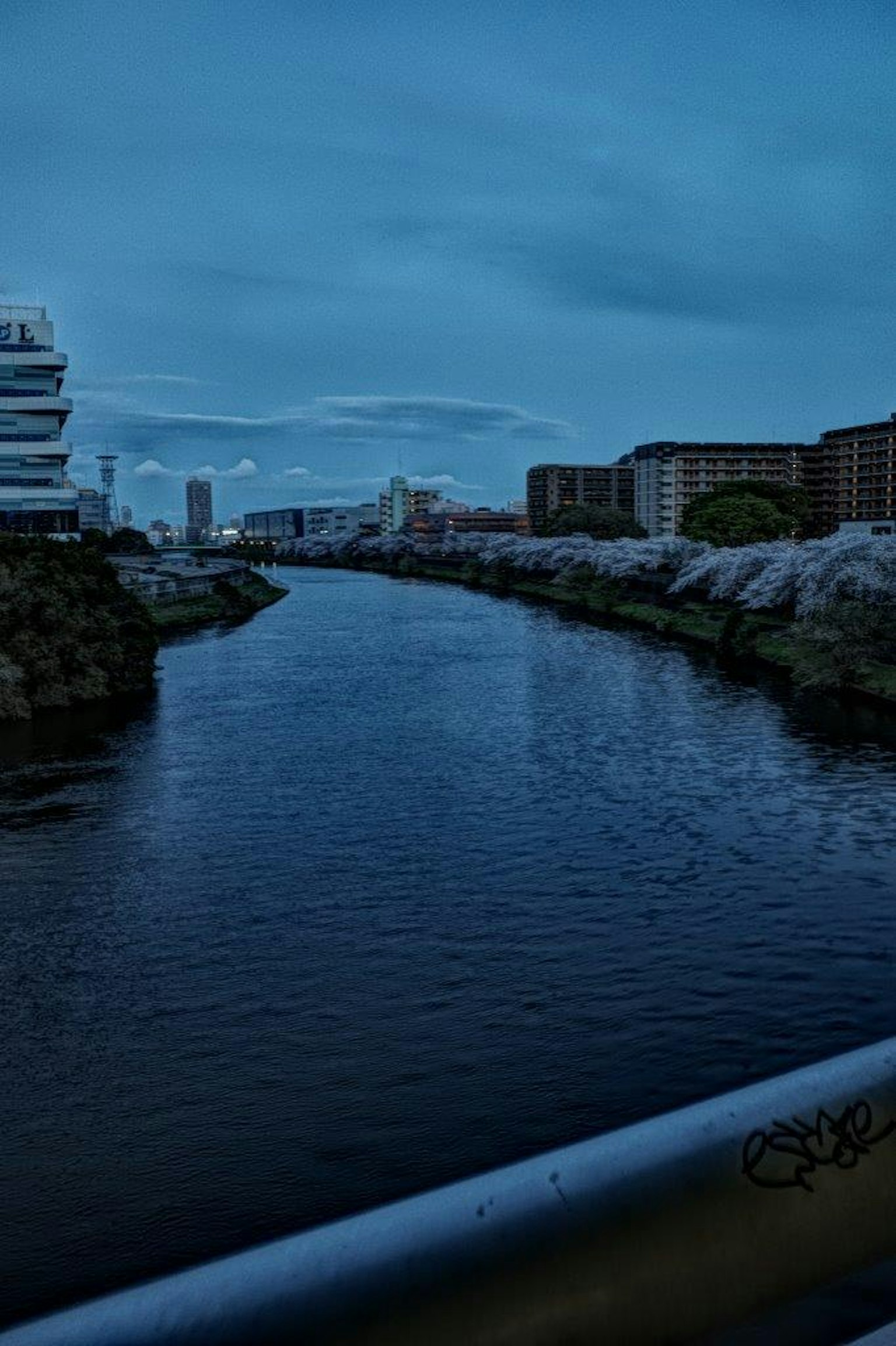 Paesaggio urbano con un fiume blu e edifici sotto un cielo nuvoloso